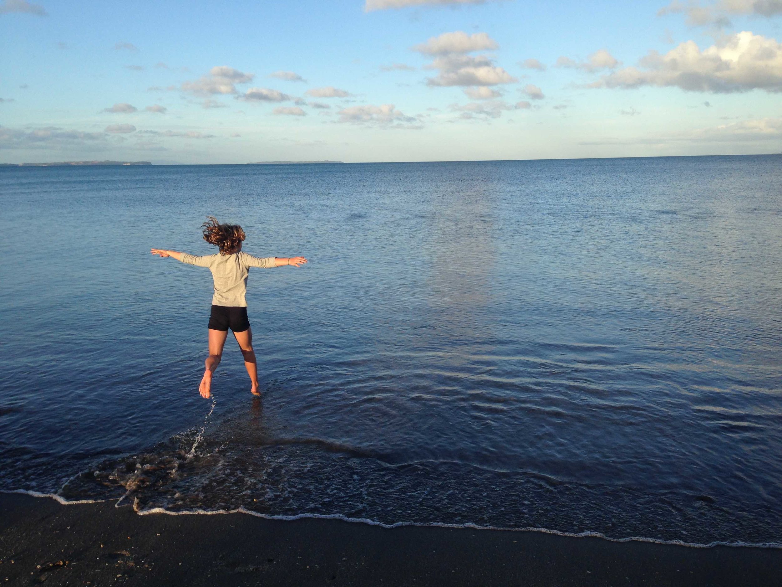 child jumping in water at Campbells Bay Auckland.jpg