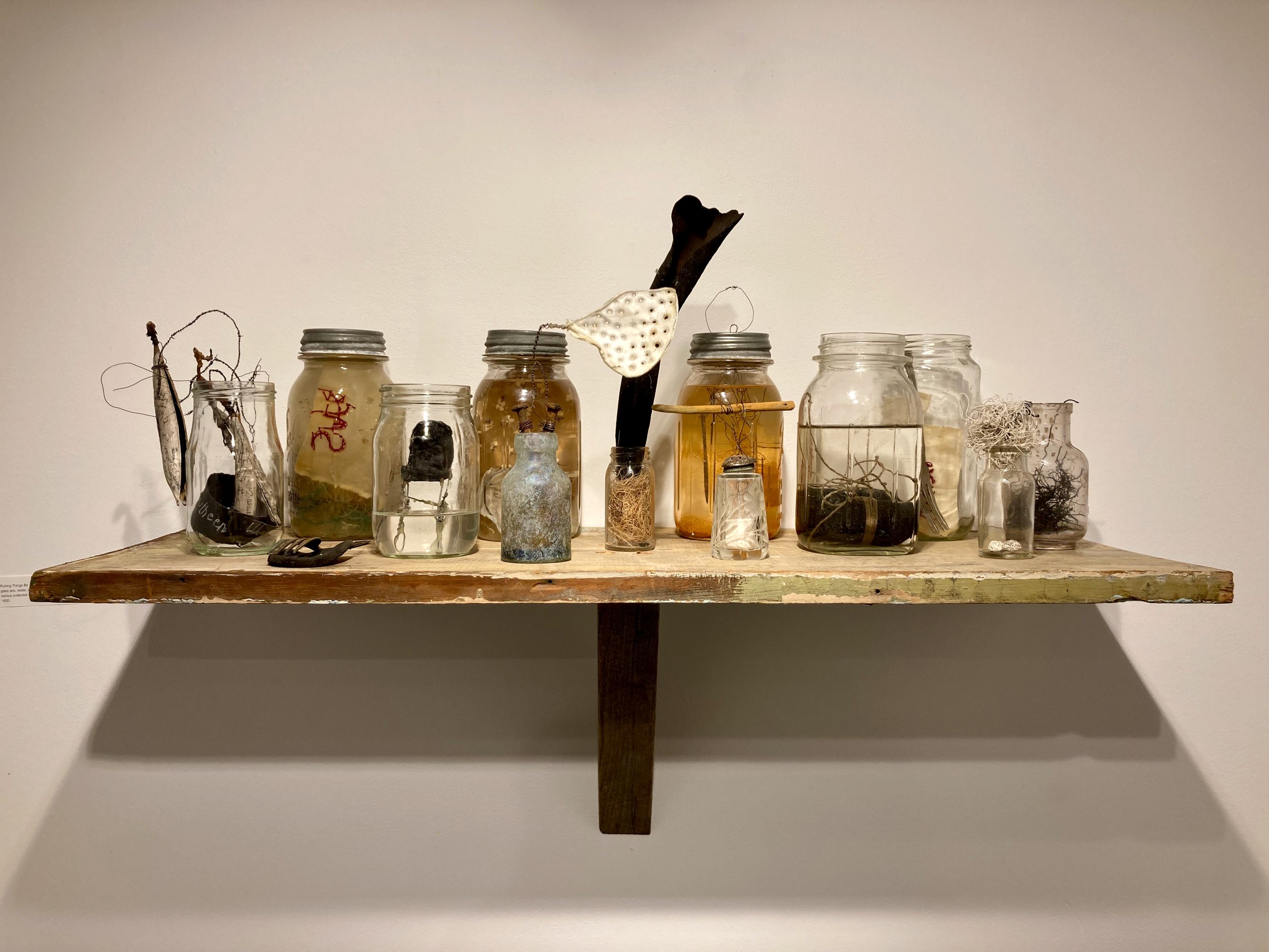   Putting Things By , 2021. Glass jars, water, wire, coal, ink, nails, paper, various collected objects. 