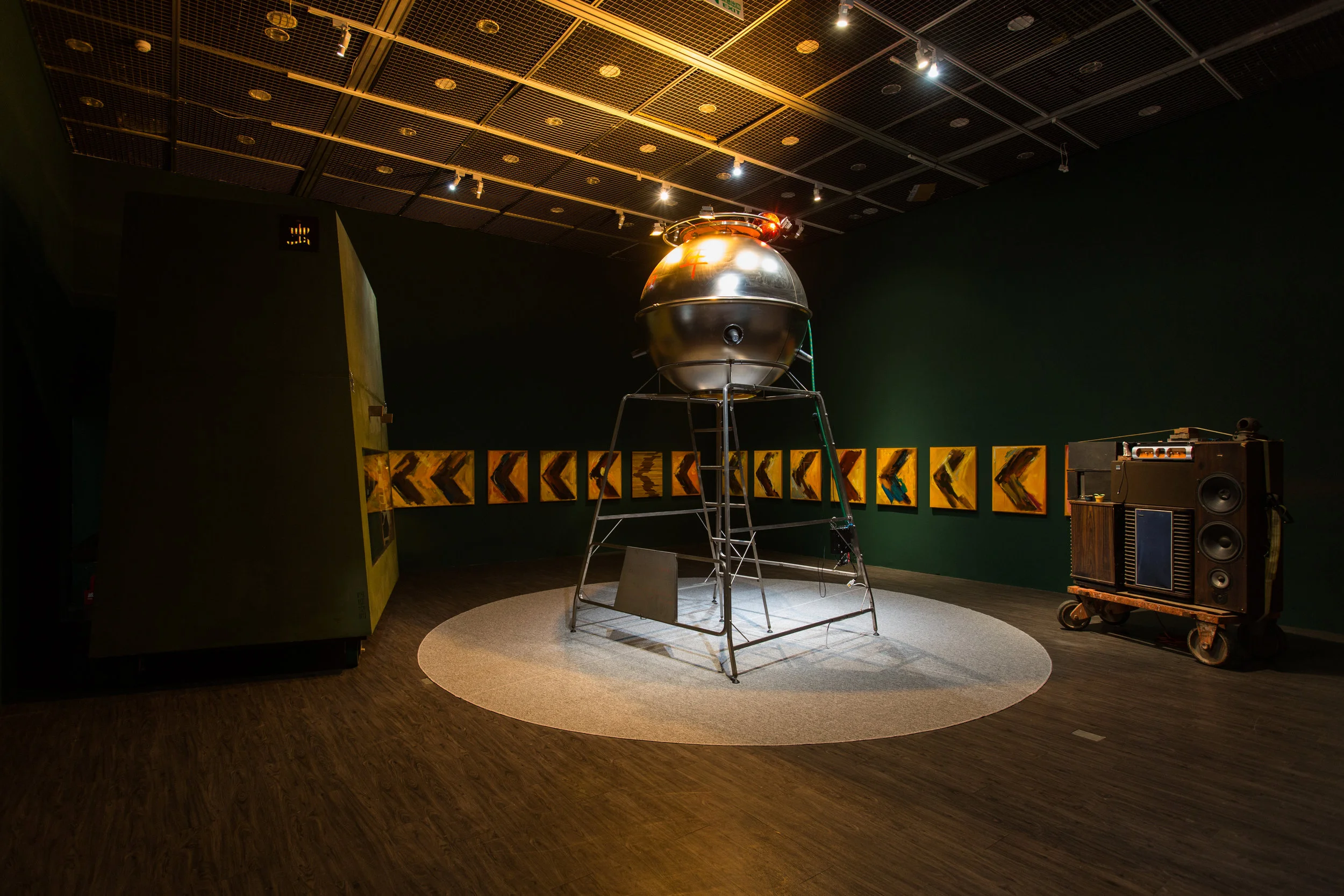  Time: 2017&nbsp;  Venue:&nbsp;Taipei Moca Museum  作品《路上的萬年站》為李承亮從現實生活的疏離狀態發展而成的場景，經由解構他自身片面的生活經驗，創造出如同煉金術般的無人劇場，其中包含多組件裝置：〈萬年站〉、〈移動的小房間〉、〈世界級環繞音響〉、〈左轉彎〉。觀者得以如遊行般移動於此想像空間，在萬年站裡可以搜尋喜歡的歌曲唱歌，也能進入小房間體驗李承亮所經歷的日常狀態：可以工作、睡覺，亦或思索生活的意義。  此作延續《月球太空計畫》的敘述奇想：李承亮