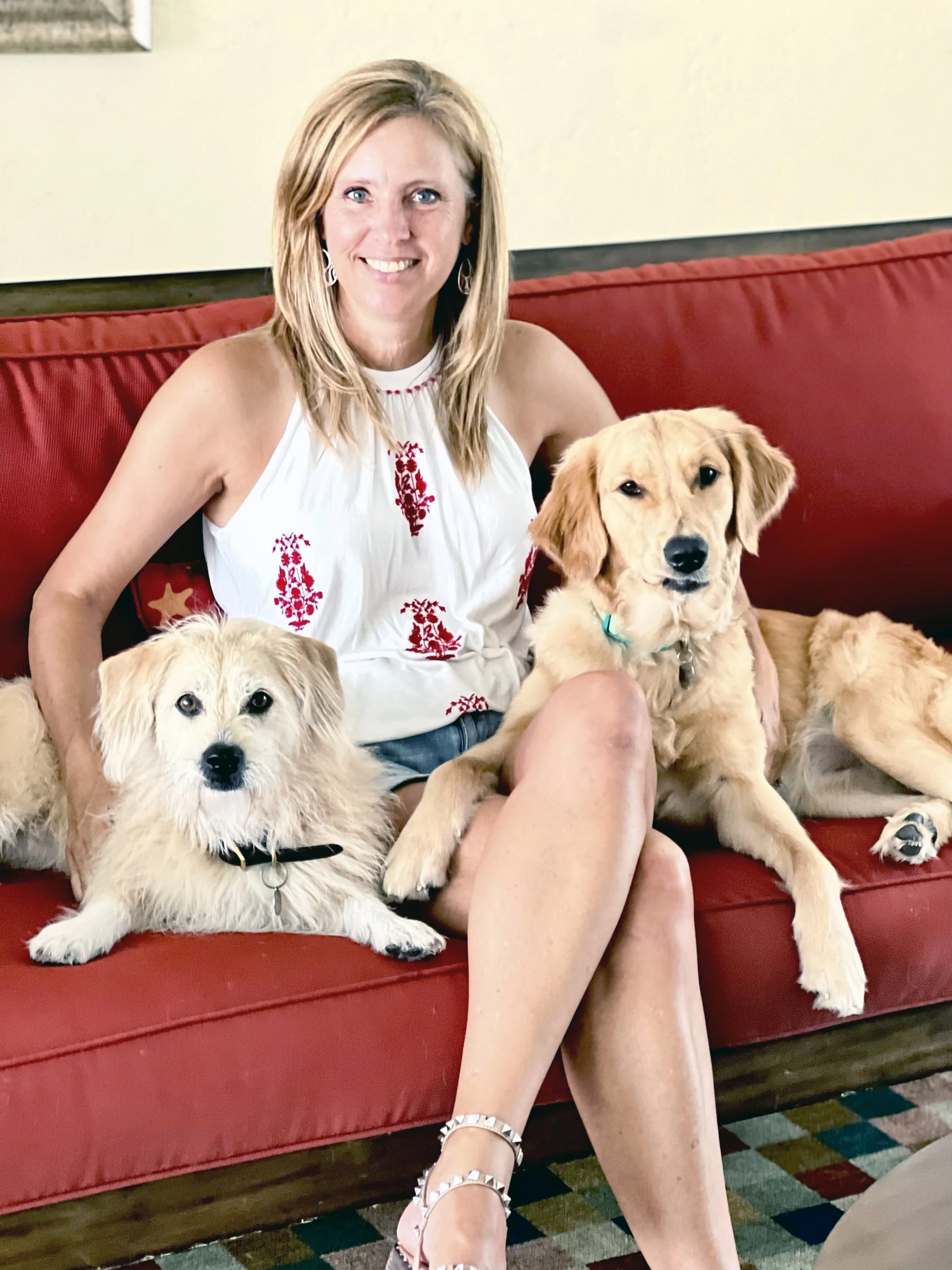 girl sitting on couch with her two dogs