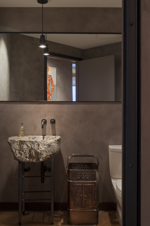 Seattle contemporary Powder Room design showing custom concrete sink handmade from piece of local Seattle highway, metal legs, full width mirror, pendant and towel rack
