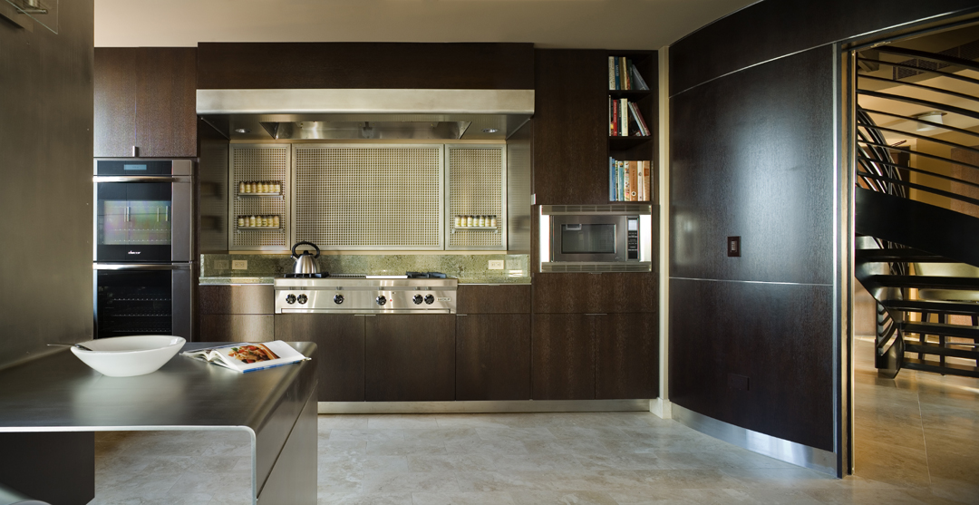 Contemporary Seattle Kitchen Design showing stained oak cabinets, a custom folded steel plate counter, and a beautiful range
