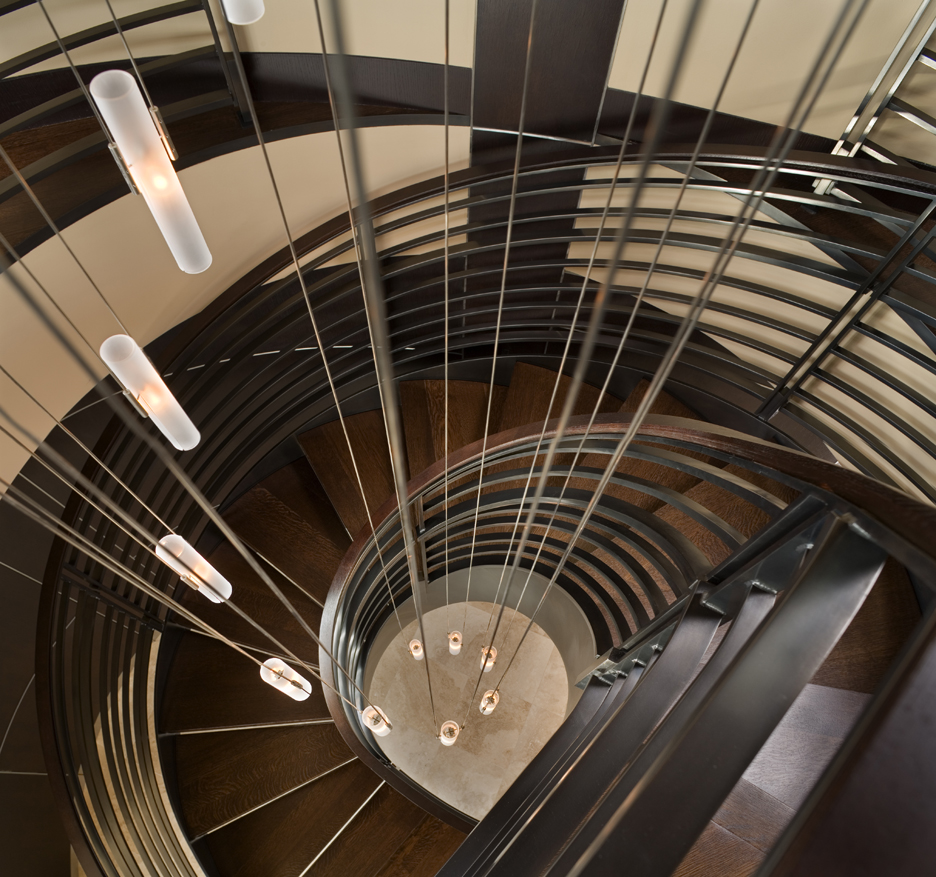 amazing spiral staircase with custom metal guardrail, stained wood treads, and spiral glass and steel chandelier 