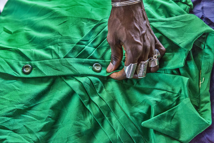 Hand with silver rings on green shirt