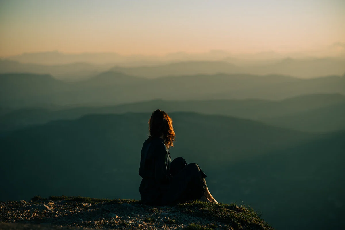 woman sitting in blue dress looking at view ay sunrise mont ventoux