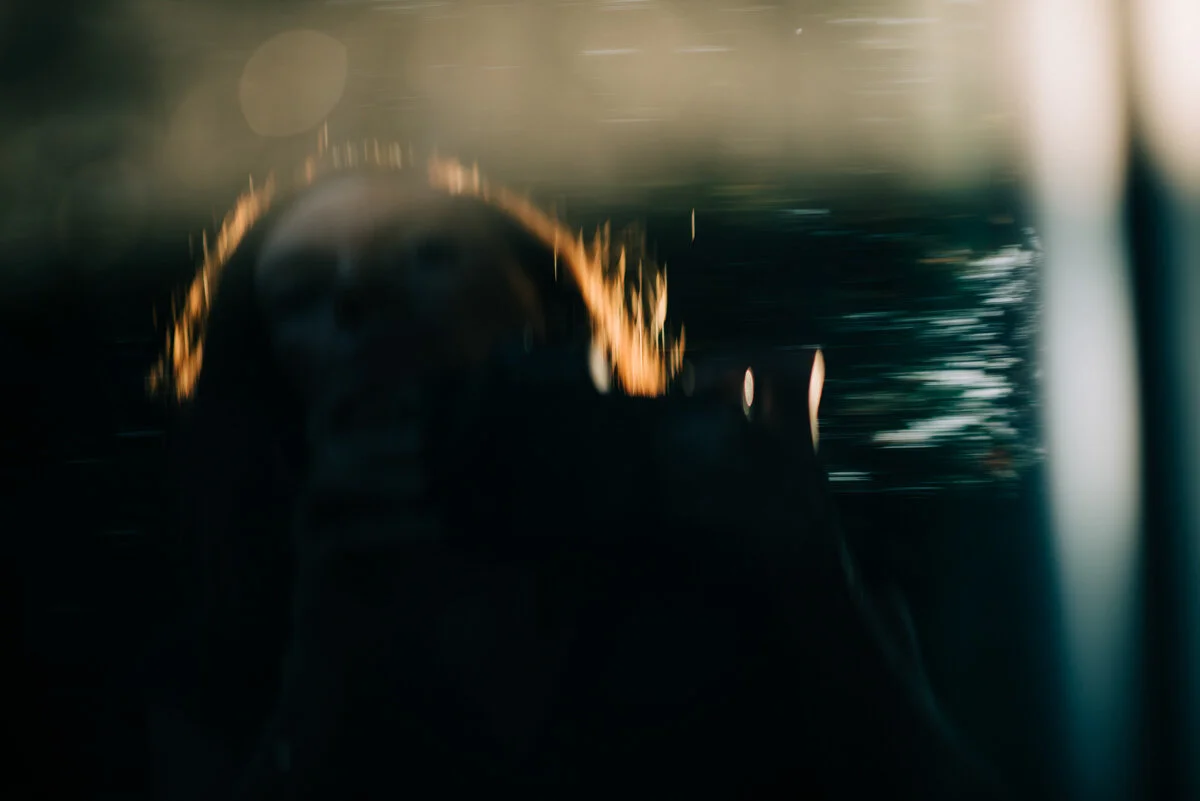 blurry dark reflection of woman with sun on hair