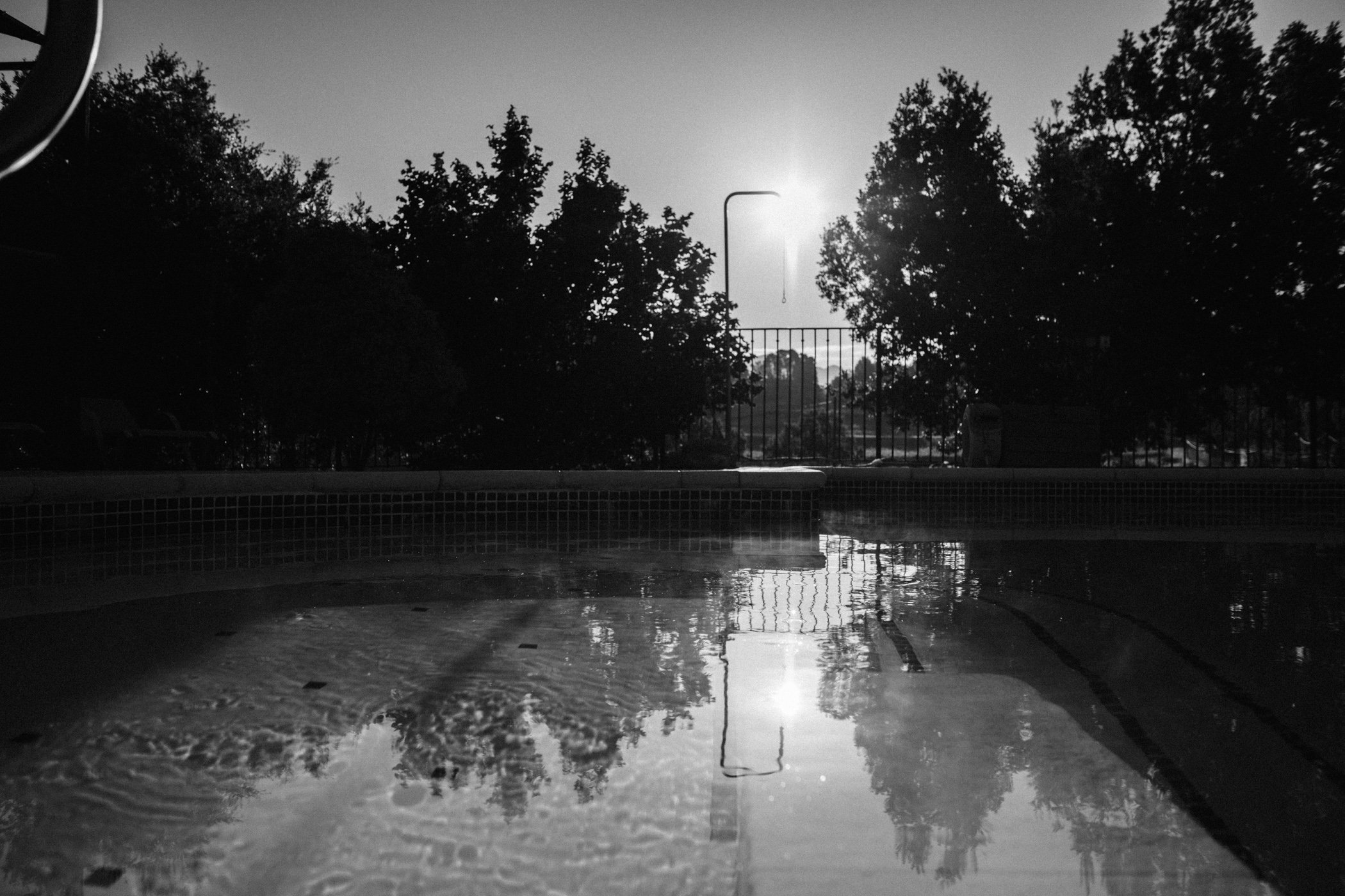 piscine au petit matin avec douche extérieur en noir et blanc