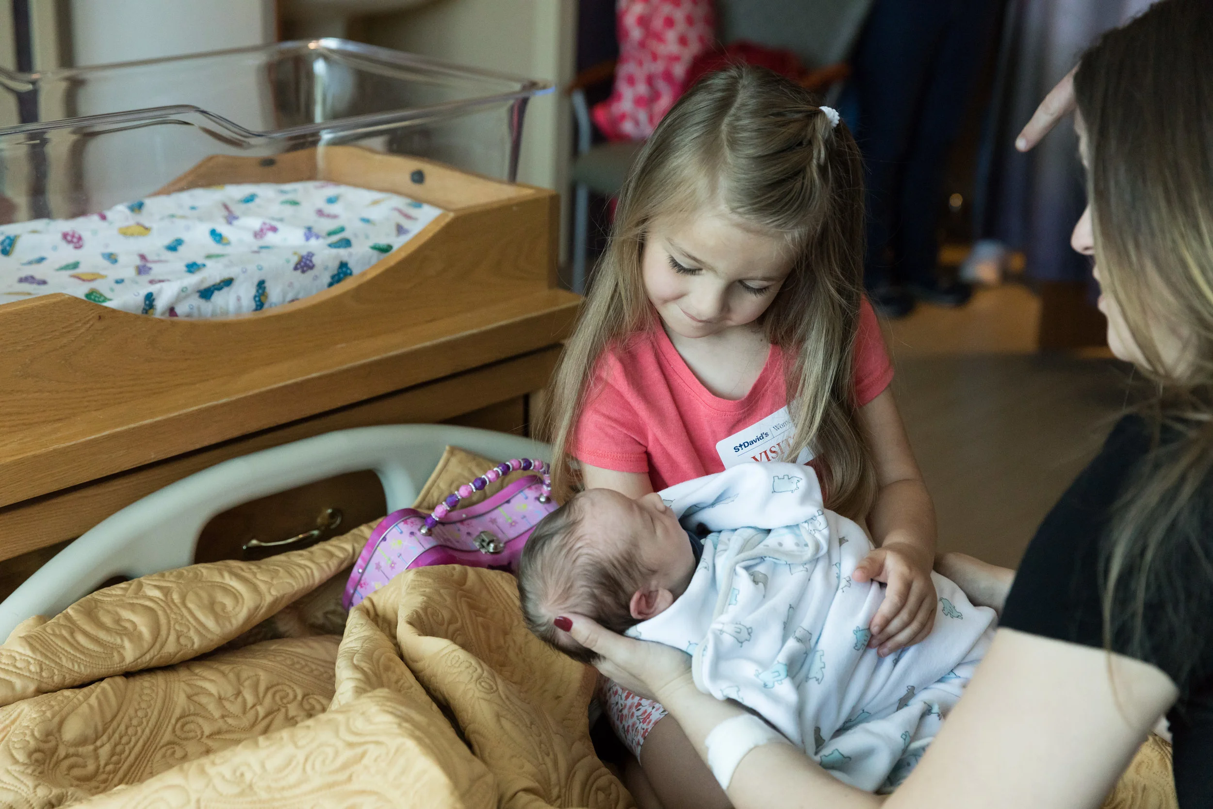 Big sister with newborn baby brother