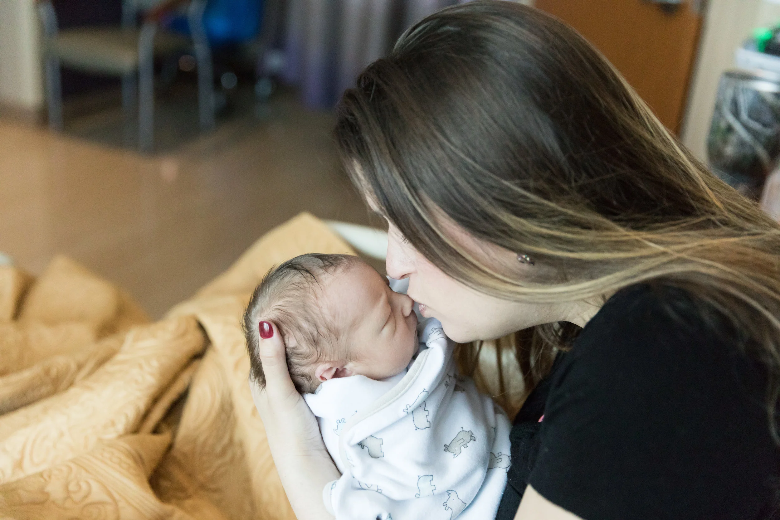 Mom kissing newborn on the nose