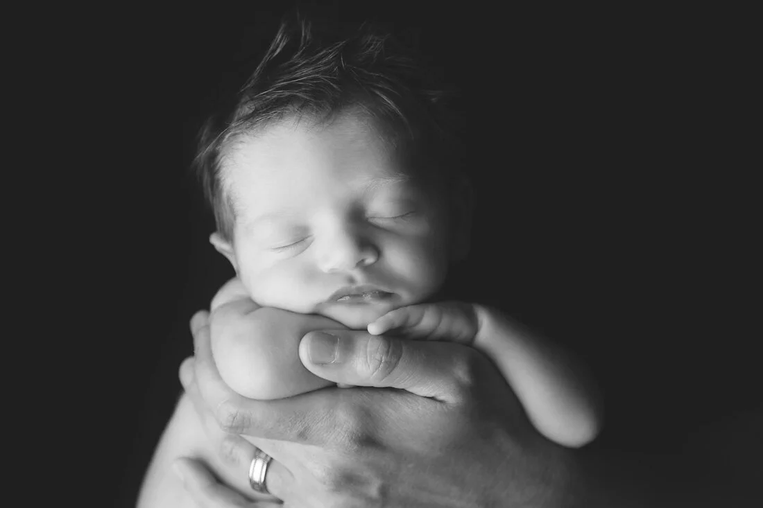 black and white newborn boy in dad's hands