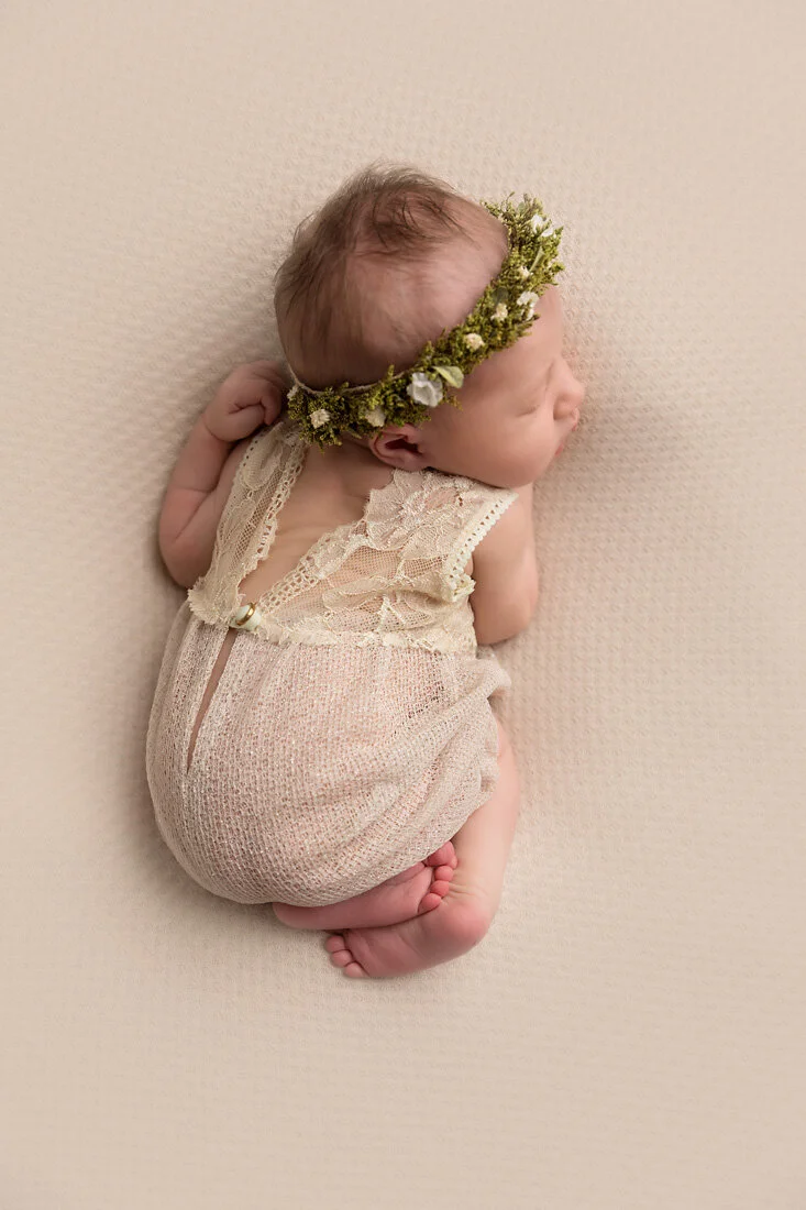 newborn girl on tan with floral headband