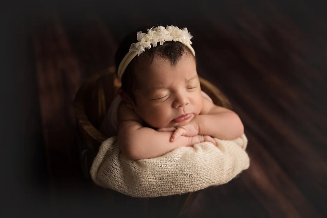 newborn girl in bucket prop