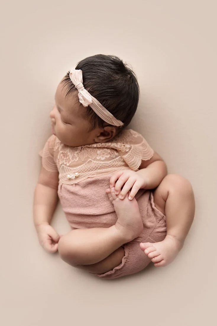 newborn girl in huck finn pose on tan