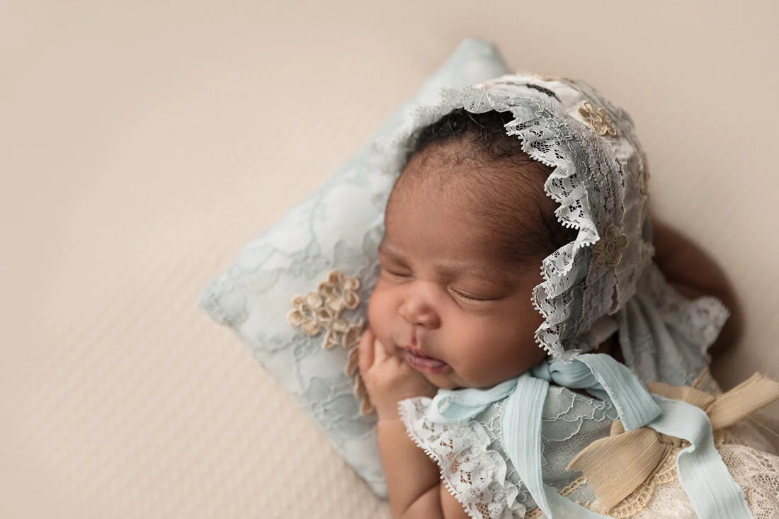 closeup newborn girl in blue bonnet