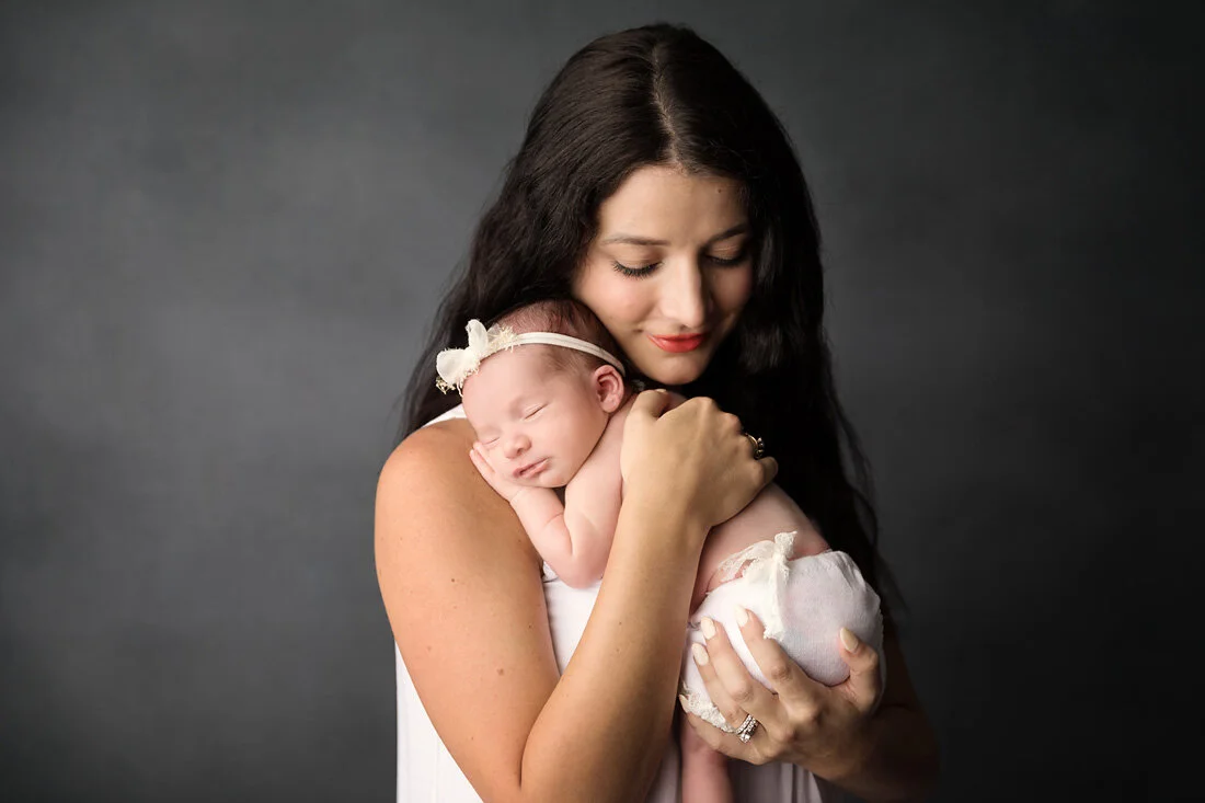 mom snuggling newborn girl