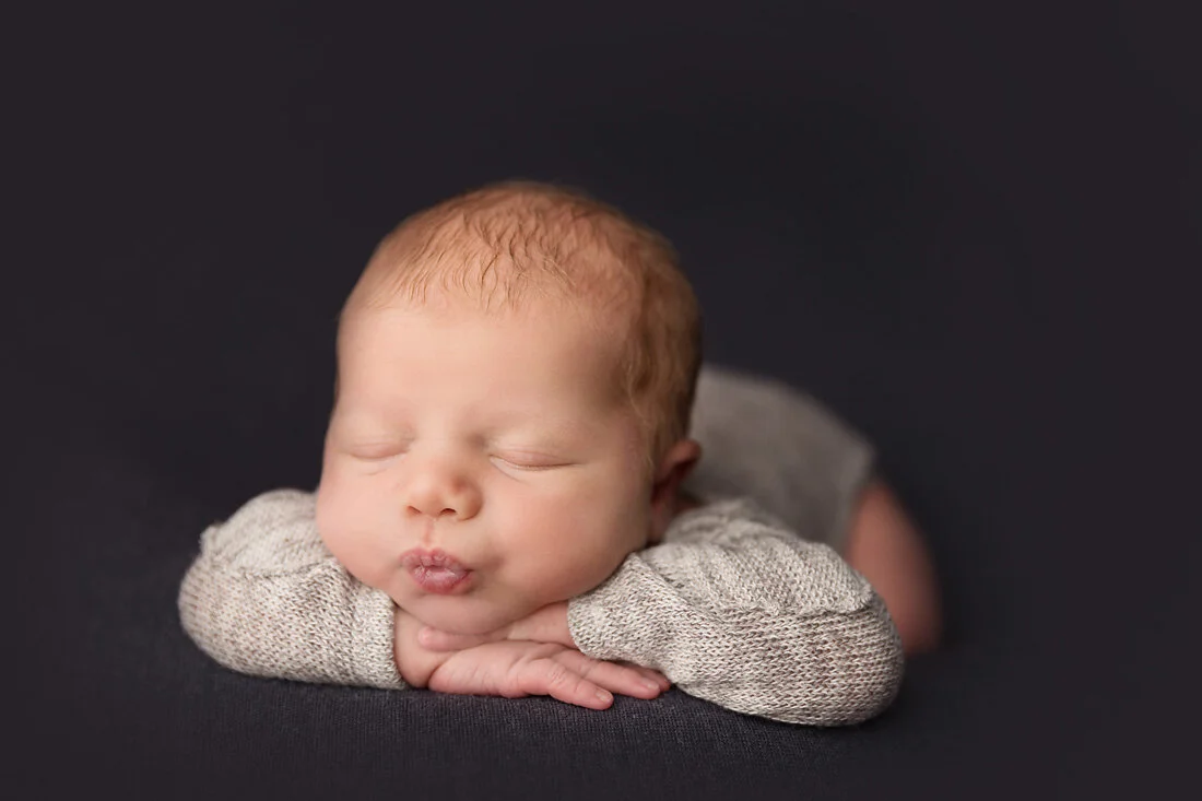head on hands newborn pose with kissy lips