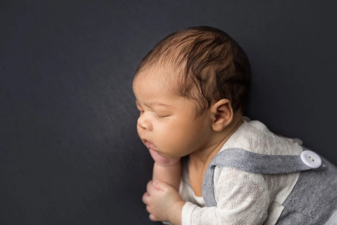 side view newborn boy with cute cheeks