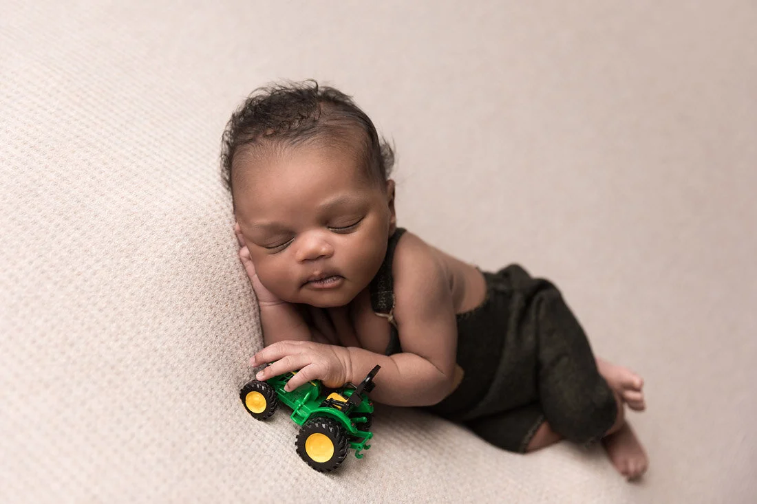 newborn boy with tractor toy