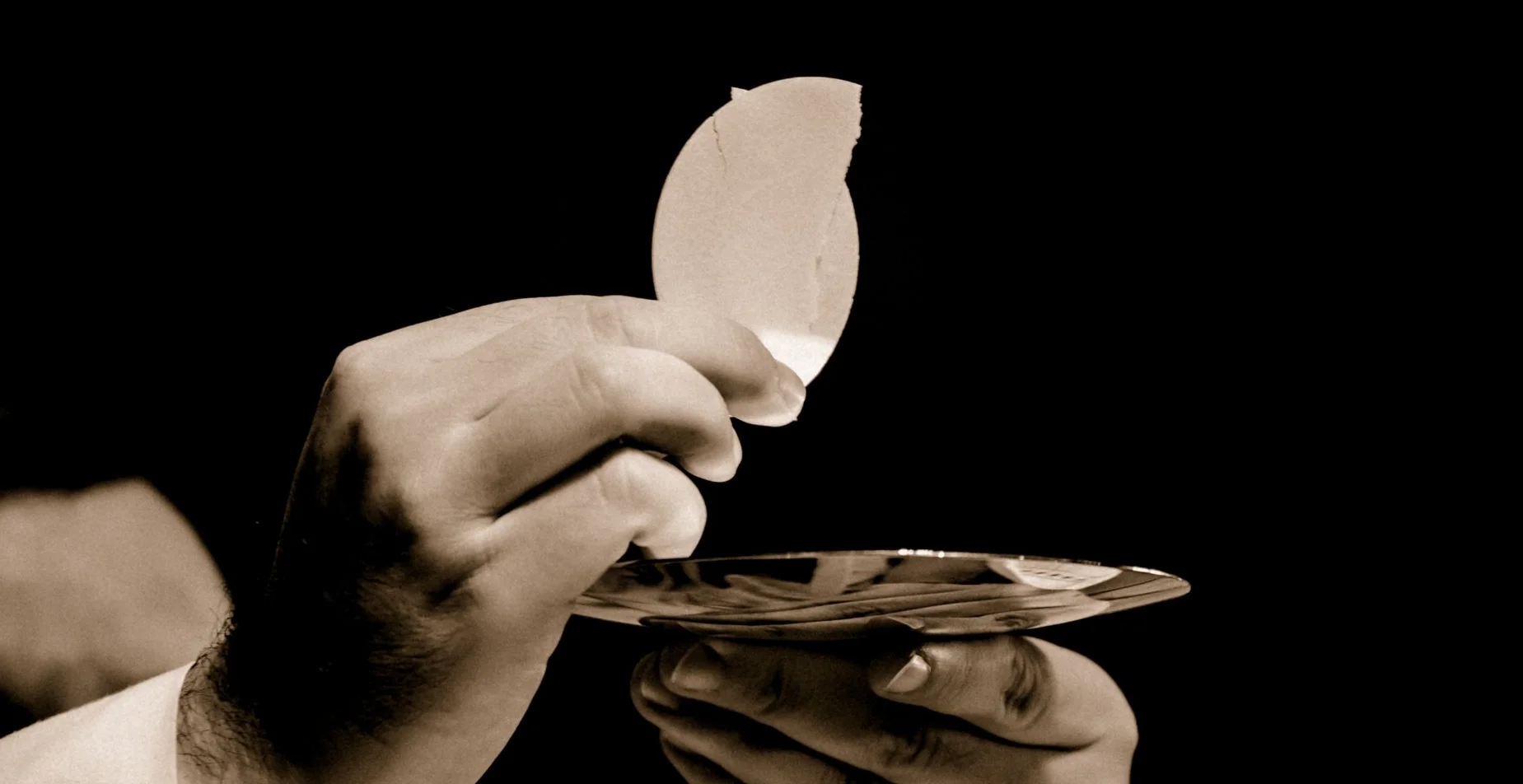 Pastor holding communion wafer (the Host) during the Divine Service.