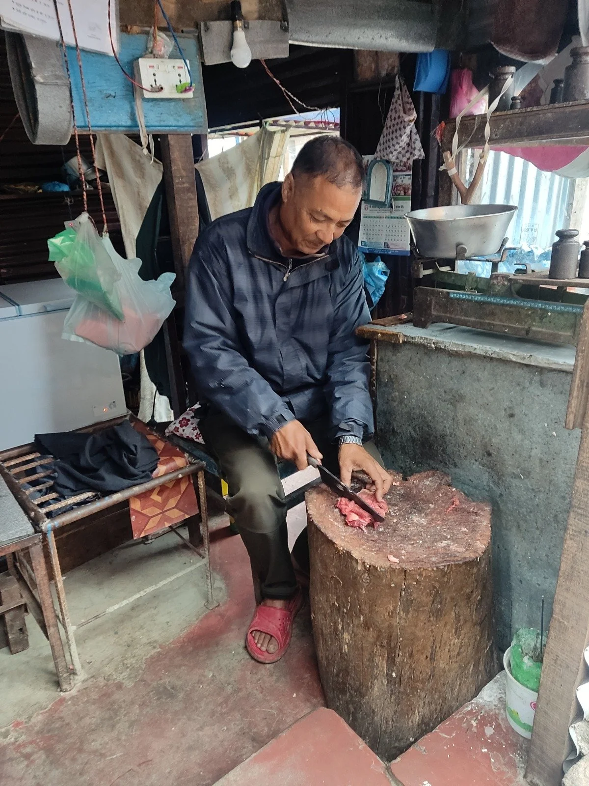  In the early morning light near Palpa Durbar, a town in Nepal's middle hills, Mangal Sahi skillfully butchers chicken and buffalo meat at his shop.  A lifelong resident of Palpa, he reflects on how much the city has changed; how land prices have soa