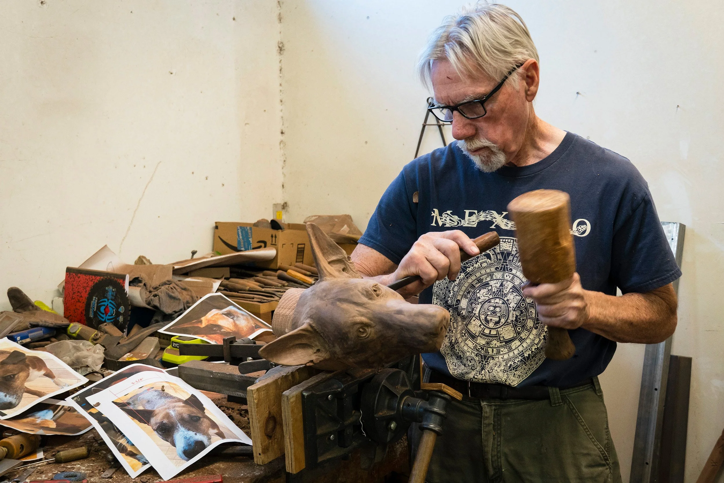 Martin hand carving the Doug dog portrait in walnut using a chisel and mallet