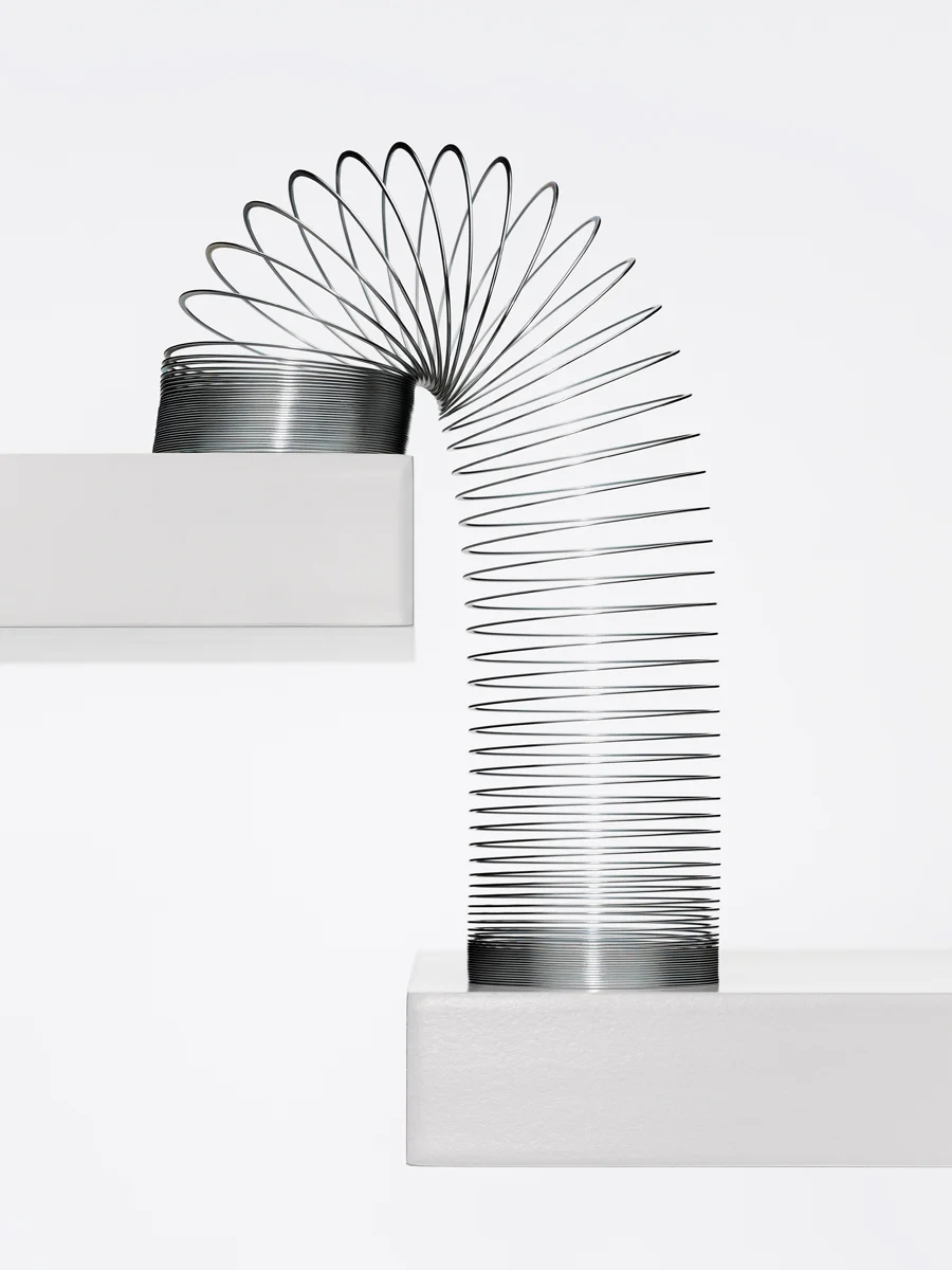 008-Metal-coil-toy(slinky)-straddling-2-shelves---white_V2_72dpi_FW.jpg