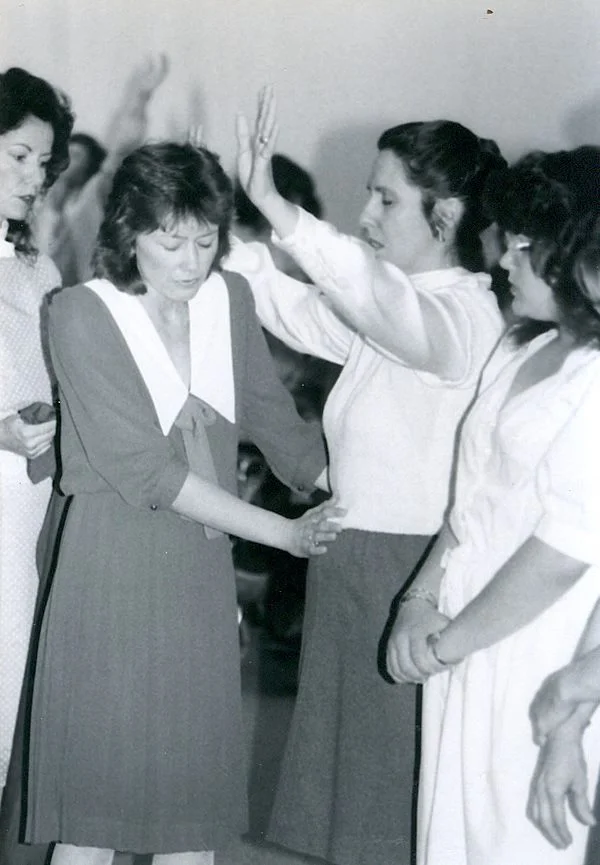 Gisele Dunn praying over Maryann Gregory