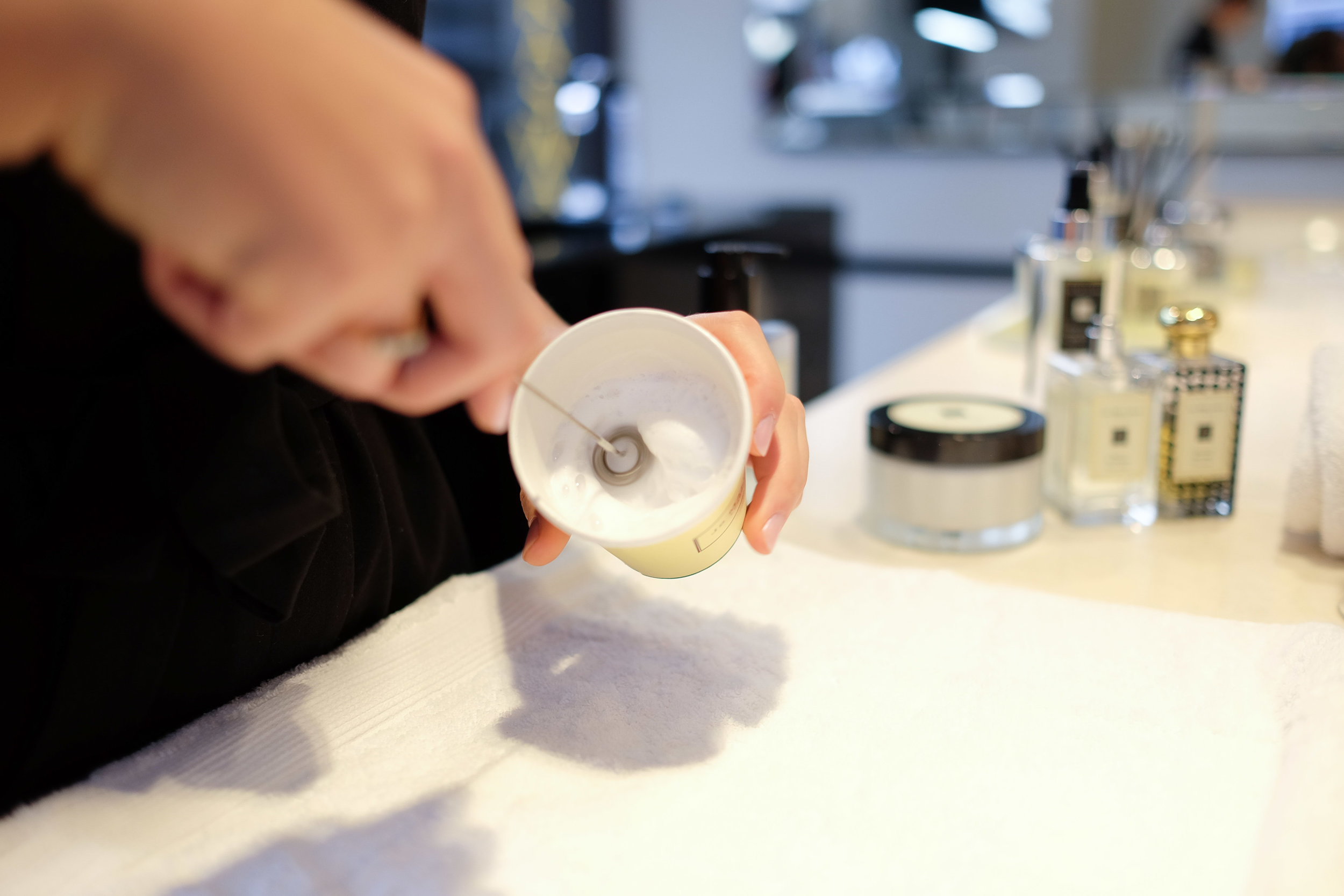 Sales assistant whisking my chosen signature hand and body wash to use for my hand and arm message. 