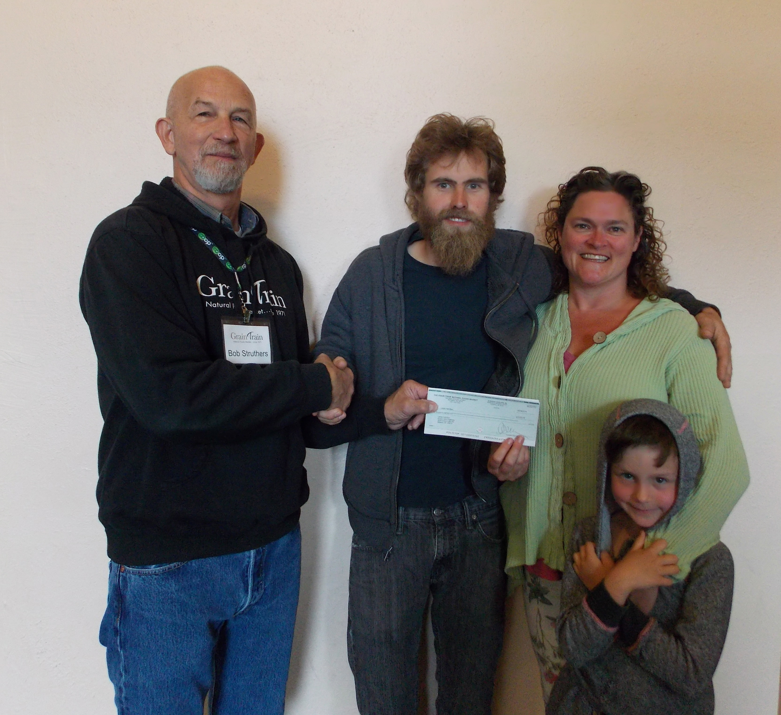 Bob Struthers, of Grain Train, and Lukas Hamilton, of Grass Lake Organics, with his family. 