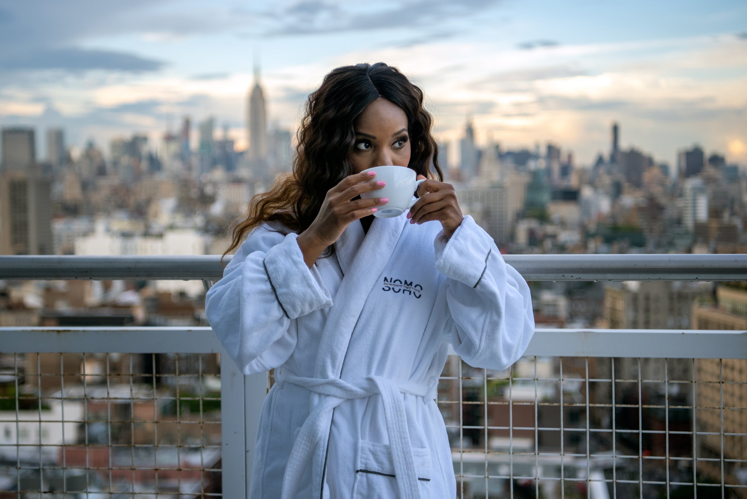girl drinking coffee on a hotel balcony at sunrise