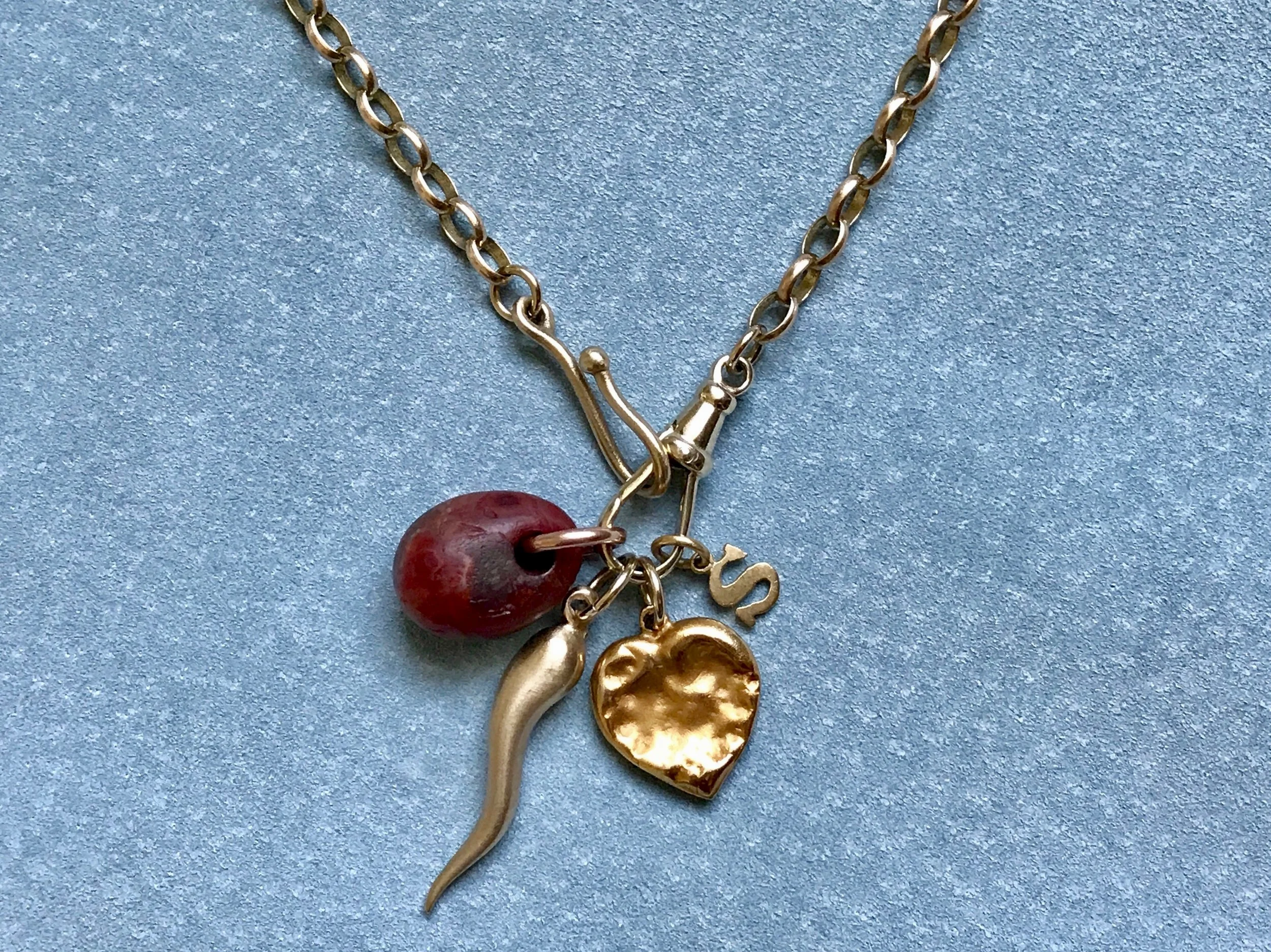 YELLOW BELCHER CHAIN WITH NEOLITHIC CARNELIAN, ITALIAN HORN, CHEWED HEART AND LETTER CHARM