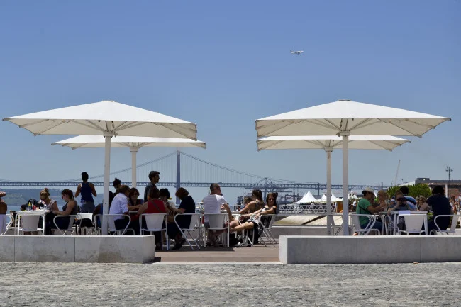 Turistas sentados numa esplanada usufruem da nova zona ribeirinha da Ribeira das Naus, localizada entre o Terreiro do Paço e o Cais do Sodré, 15 de julho, em Lisboa (Tiago Marques/ Lusa)