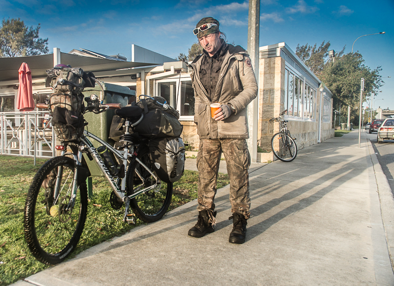 Scotty's life is loaded into canvas bags on the side of his bike. He says he has adapted the bike as he has travelled, adding extra comforts like solar panels to soften life on the road. 