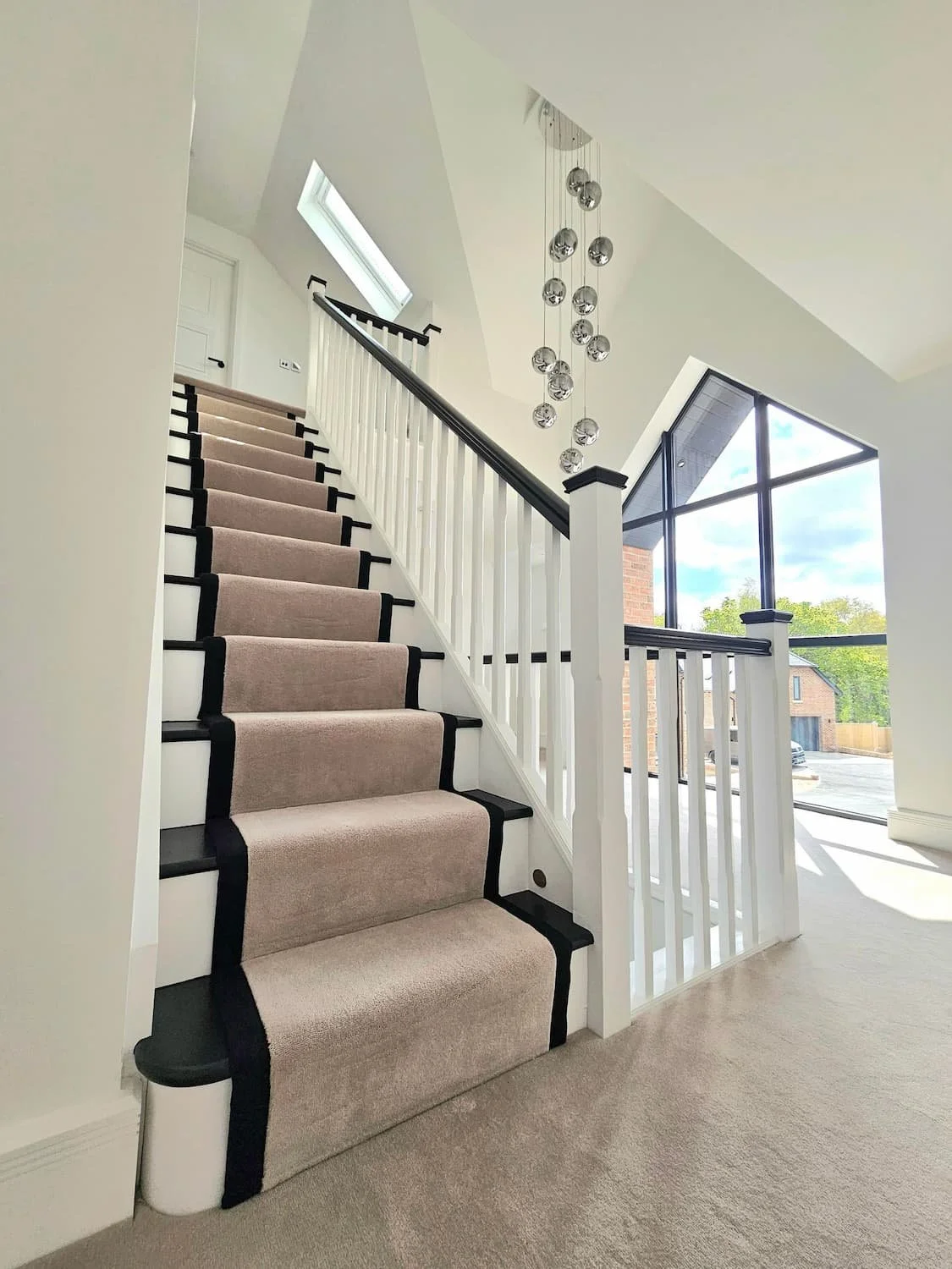 Luxury decorator hill head, paintology. Beautiful black and white staircase with carpet runner.