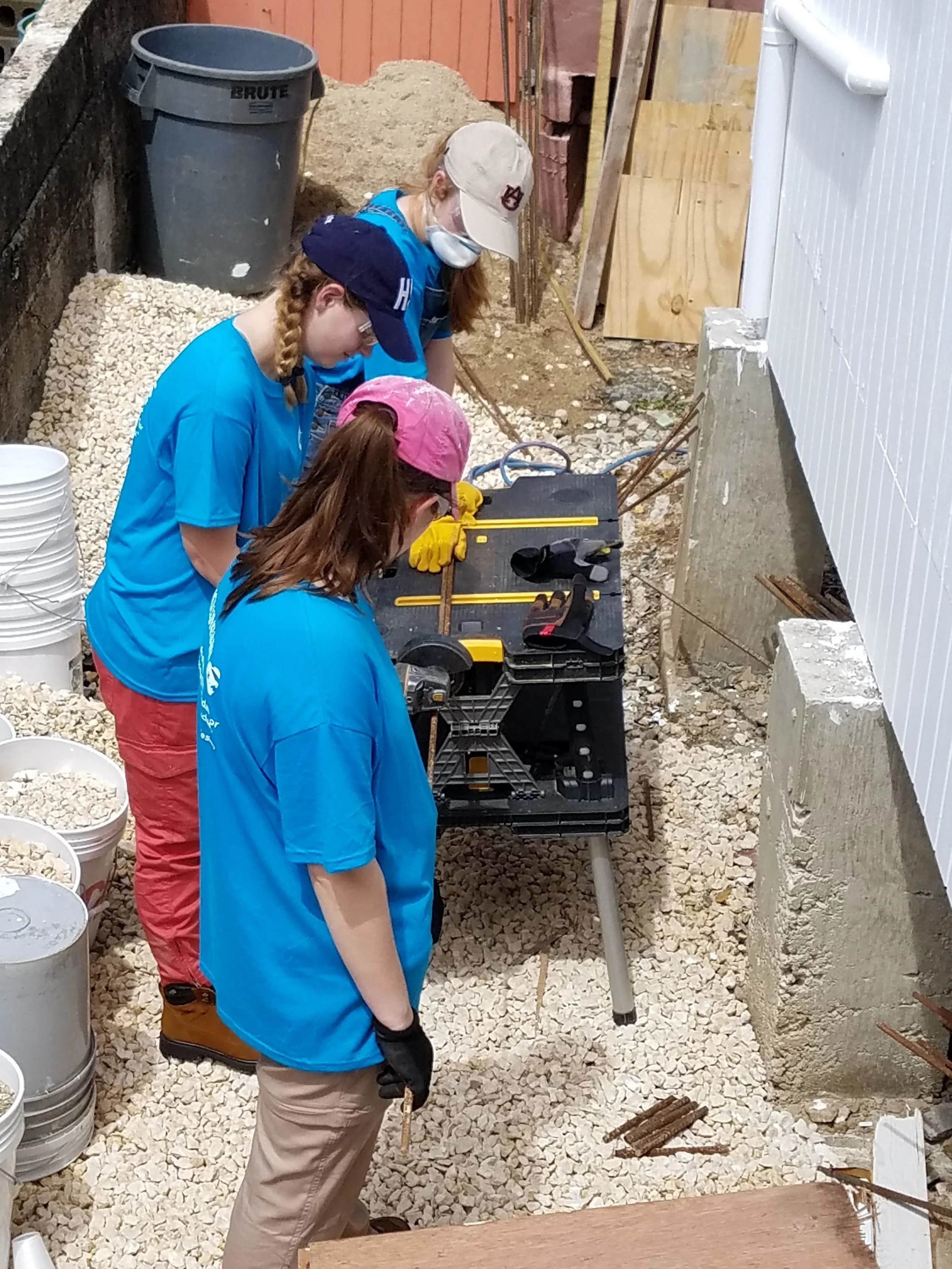 Bekah Wommack, Megan Kucera, and Sarah Jane Thompsonfrom Team 3 are shown cutting rebar. They spent most of the day sorting wood, rebarring, and doing a wide variety of other things.