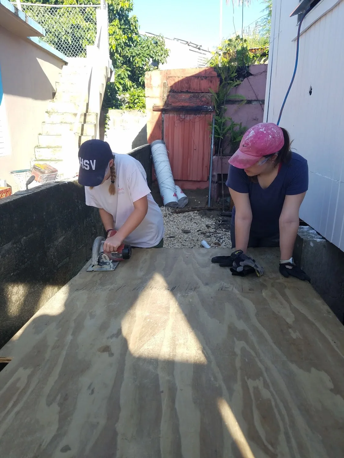 Megan Kucera and Sarah Jane Thompson cut some wood