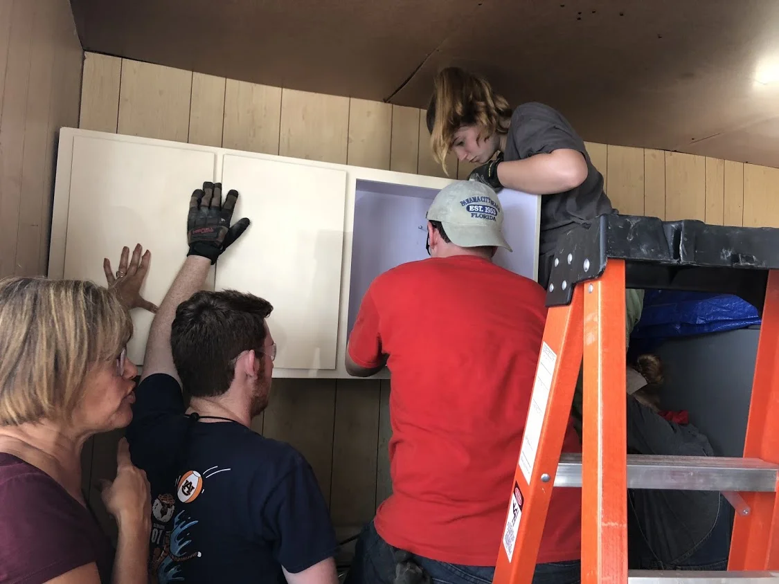 Team Hot Pants (Ben Gourley, Josh Ellis, Megan Kucera install/replace a cabinet