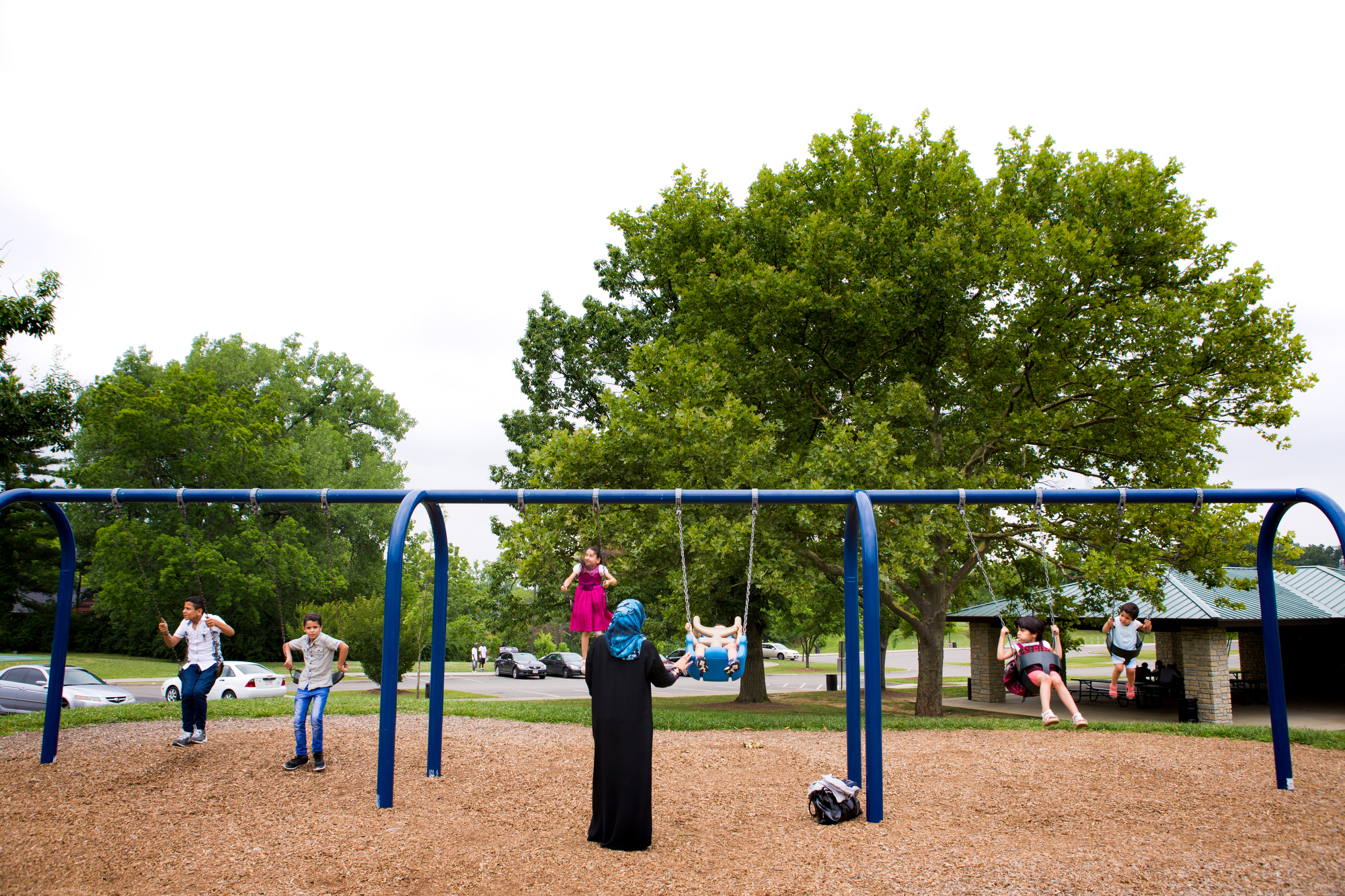  Hasan, Hussein, Zina, Yousif, Rimas and Ghalia Alhamoud swing at a local park after an Eid al-Fitr celebration with other Muslim refugees at Catholic Charities on July 7, 2016. 