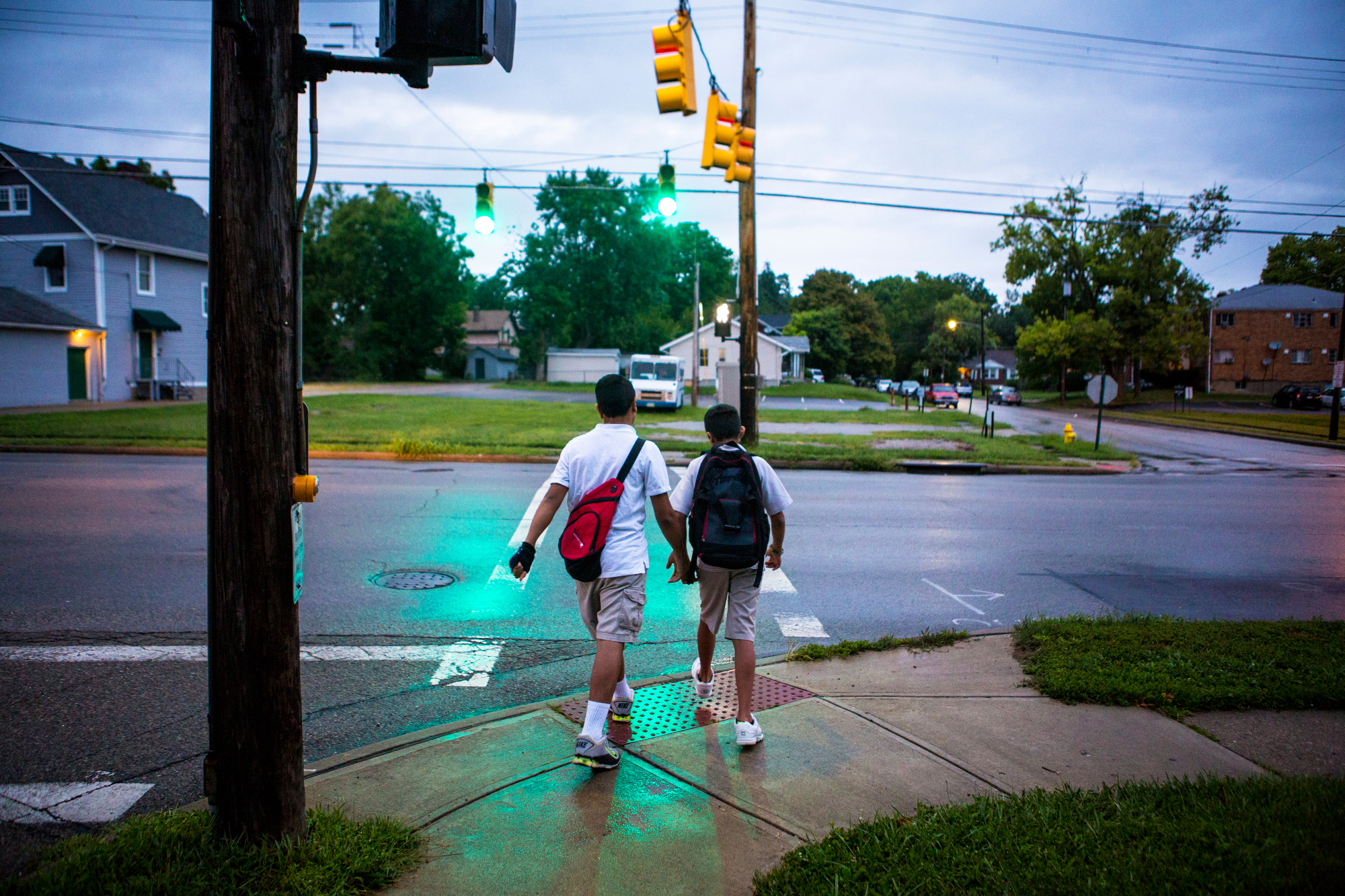  Hasan and Hussein Alhamoud cross the street to catch their bus to Withrow University High School on Wednesday, August 17, 2016. The brothers want to be dentists. 