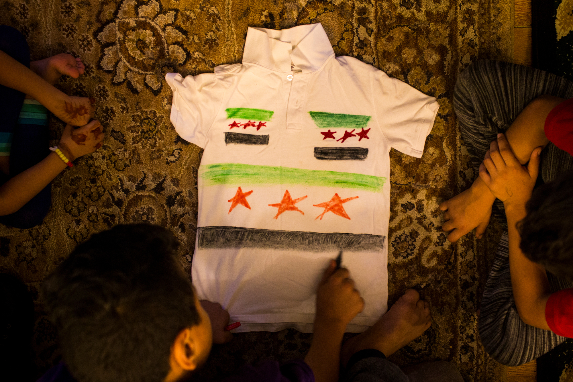  Hasan Alhamoud draws a Syrian flag on one of his uniform shirts on Thursday, October 6, 2016. 