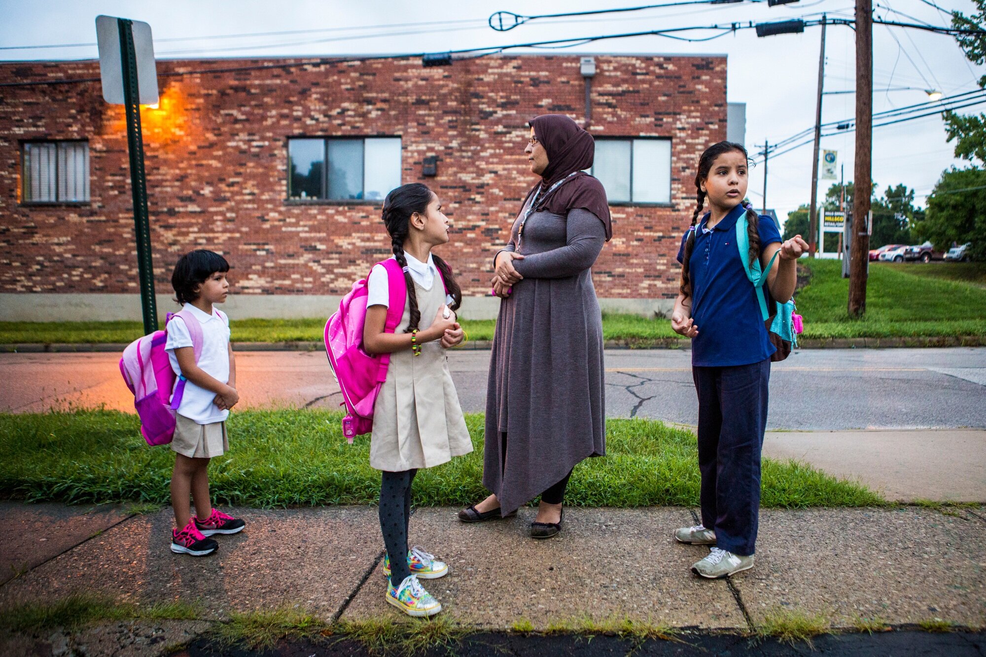  Rimas, Zina, and Dalal Alhamoud wait with their mother at the bus stop for their first day of school on Wednesday, August 17, 2016. 