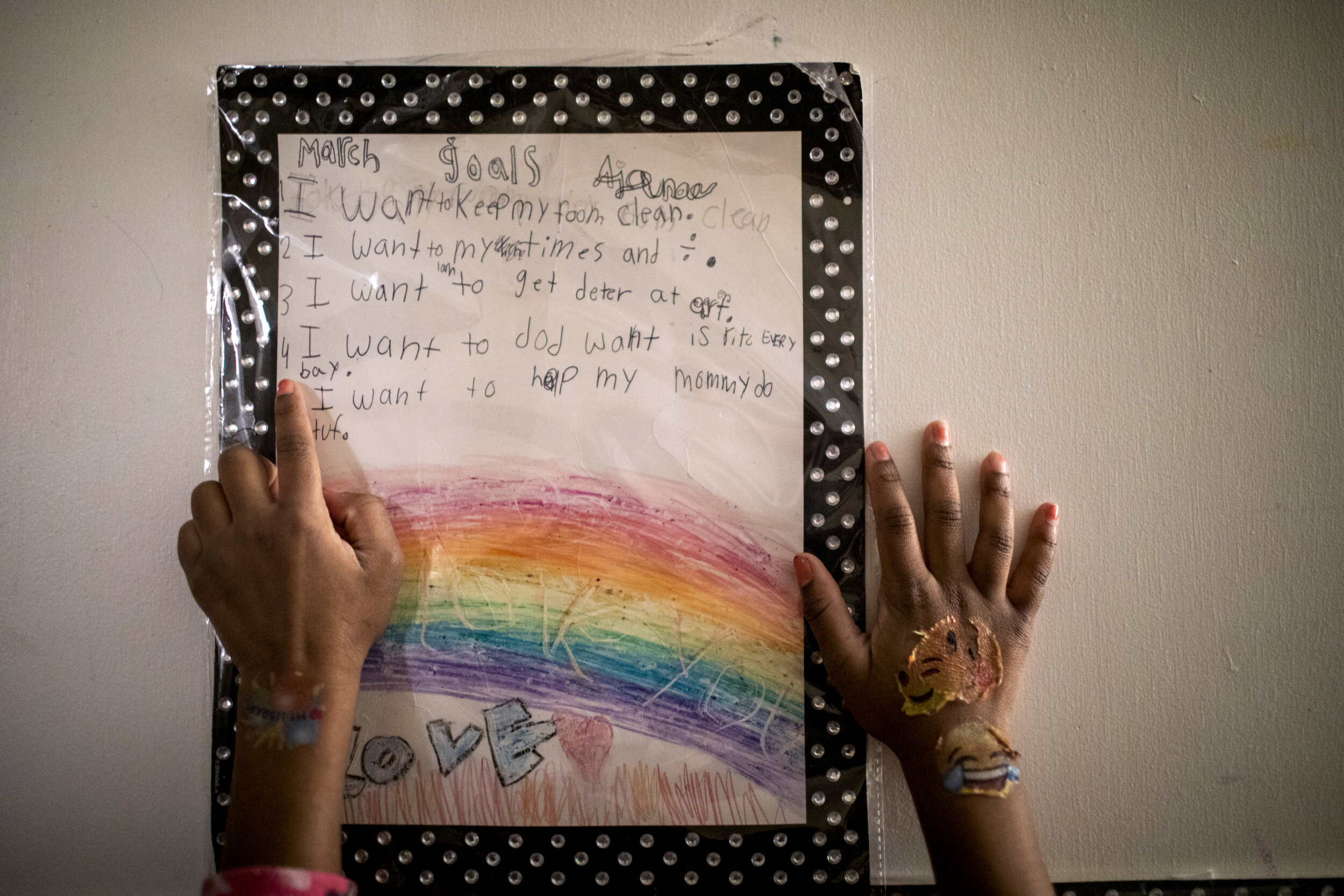  Ajaunae, 8, reads her goals for March that are taped to her bedroom door. She wants to help her mommy do stuff and keep her room clean. 