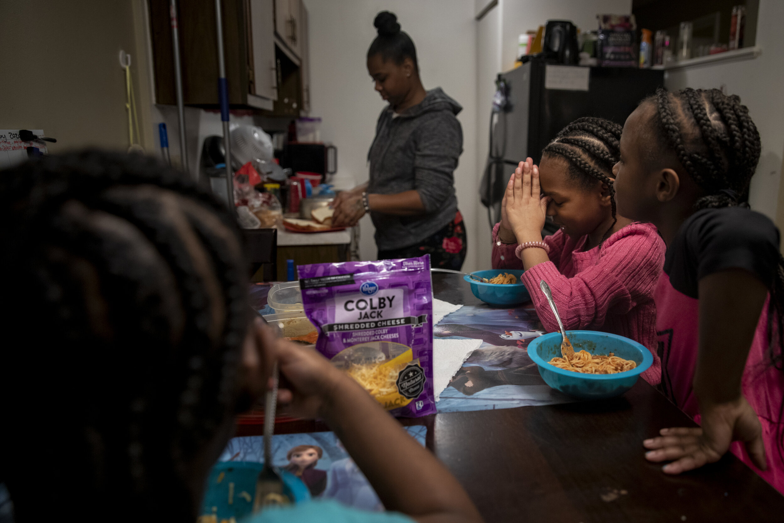 Amariyonna, 9, prays before eating dinner with her sisters and mom. 