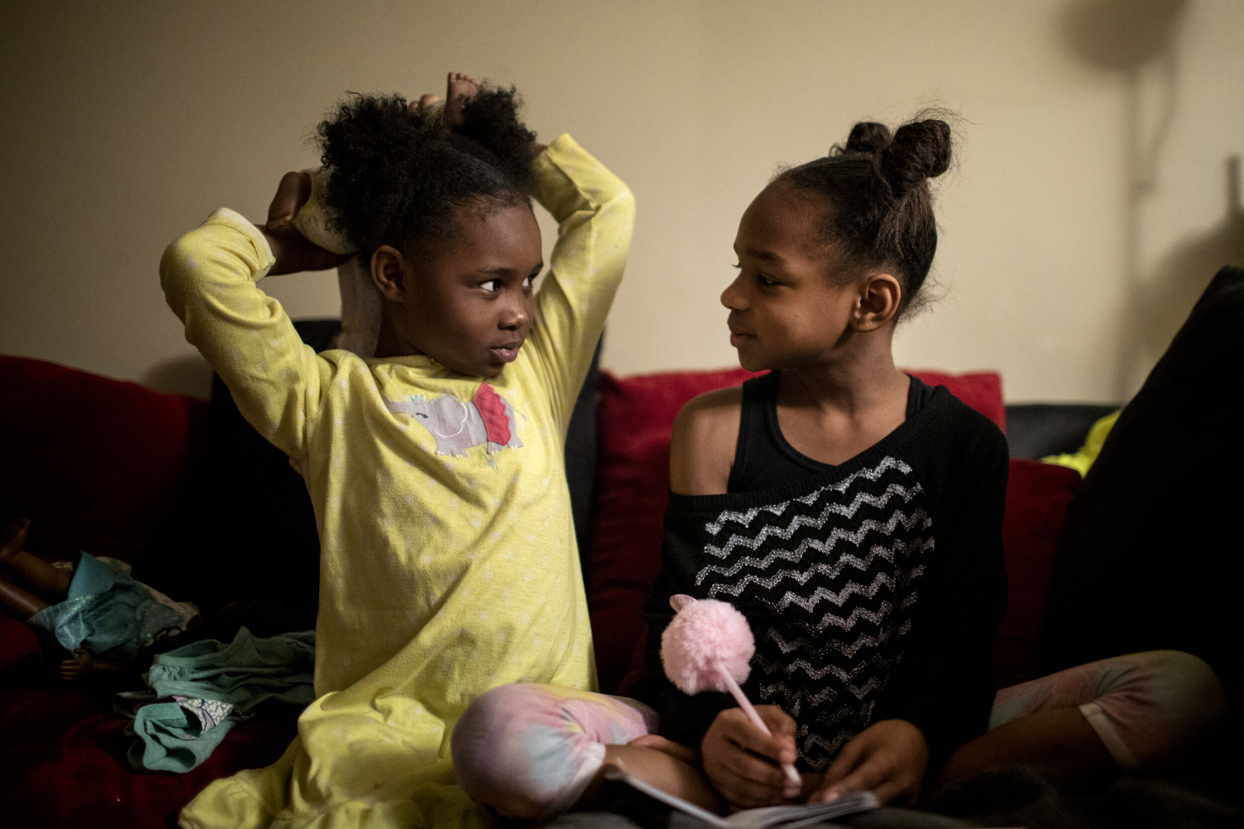  Angelina, 7, watches her older sister Amariyonna, 9, write in her journal as they get ready for bed. 