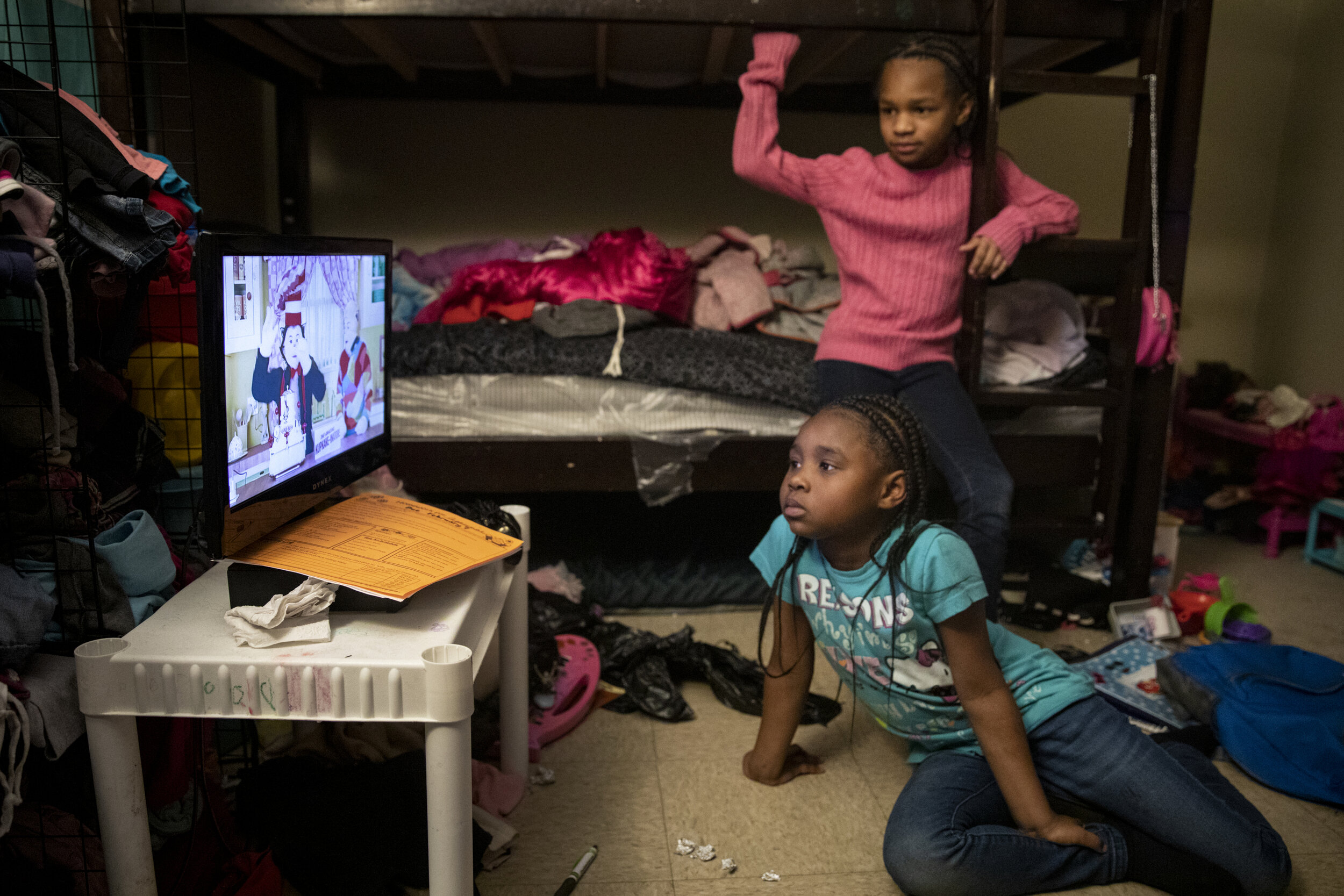  Angelina, 7, and Amariyonna, 9, watch "The Cat in the Hat" in their shared bedroom after finishing their homework. 