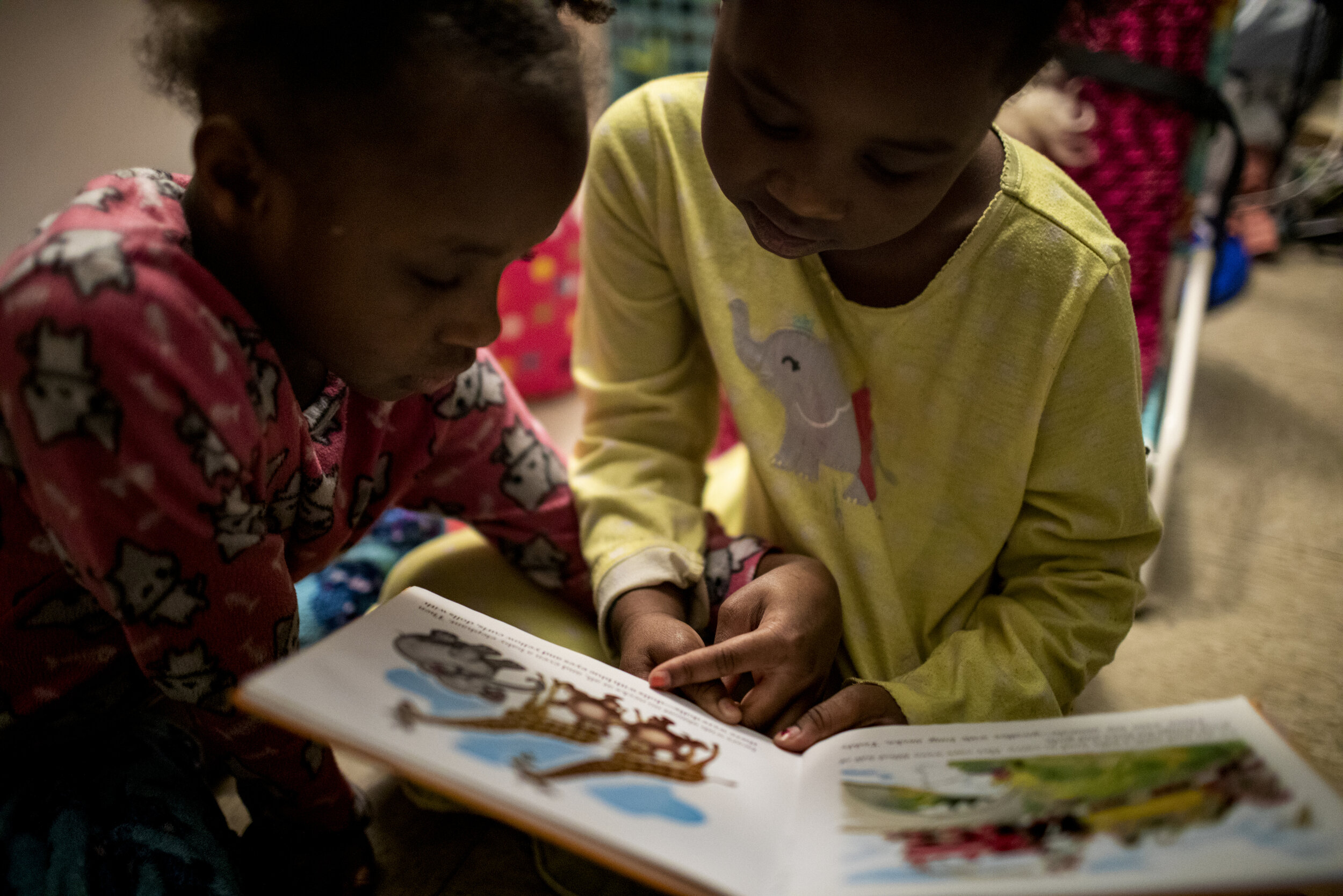  Ajaunae, 8, and Angelina, 7, read "The Little Engine That Could" before going to bed. 