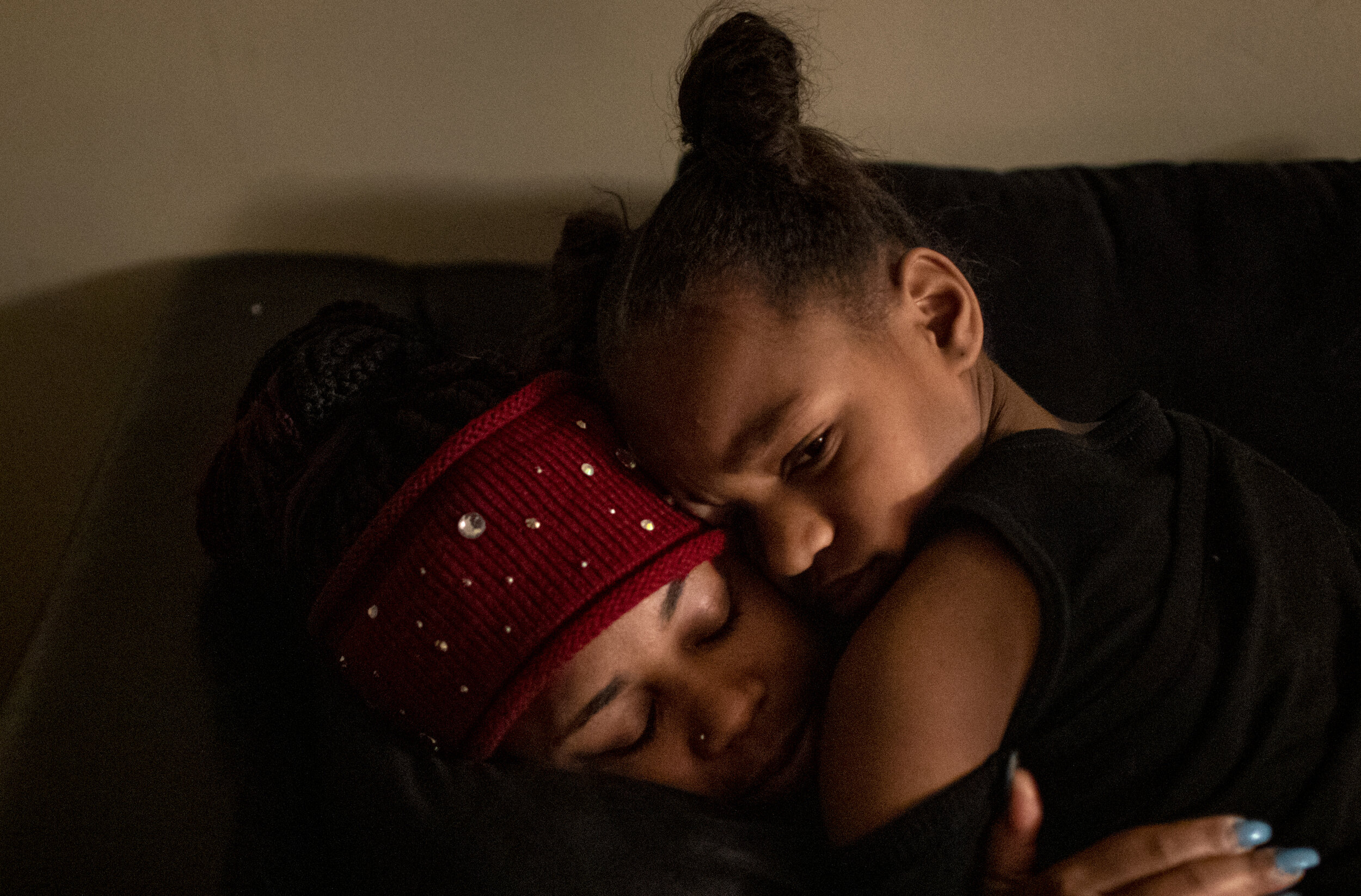  Amariyonna, 9, hugs her mom Paige Berry before Berry leaves her Westwood apartment to go to work moving freight on a rainy airport tarmac. 