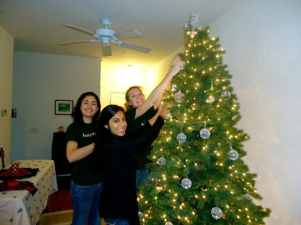 Alexa (center) and fellow volunteers decorate a client’s tree for the holidays