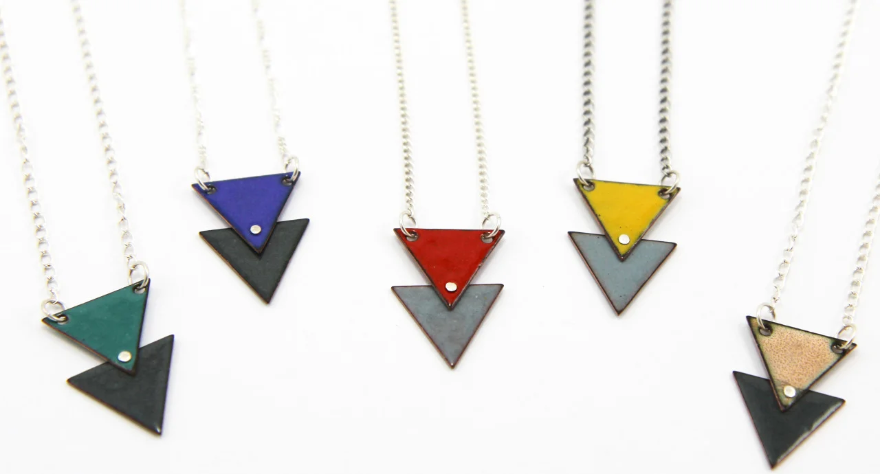 Introducing my brand new Double Triangle Enamel Necklaces in five fun color combinations.
These lovelies start out as two tiny copper triangles that I drill with holes, kiln-fire at 1500 degrees with colored glass enamel, rivet together with a fine silver rivet and complete with an 18" sterling silver chain.
Check them out in my etsy store today.