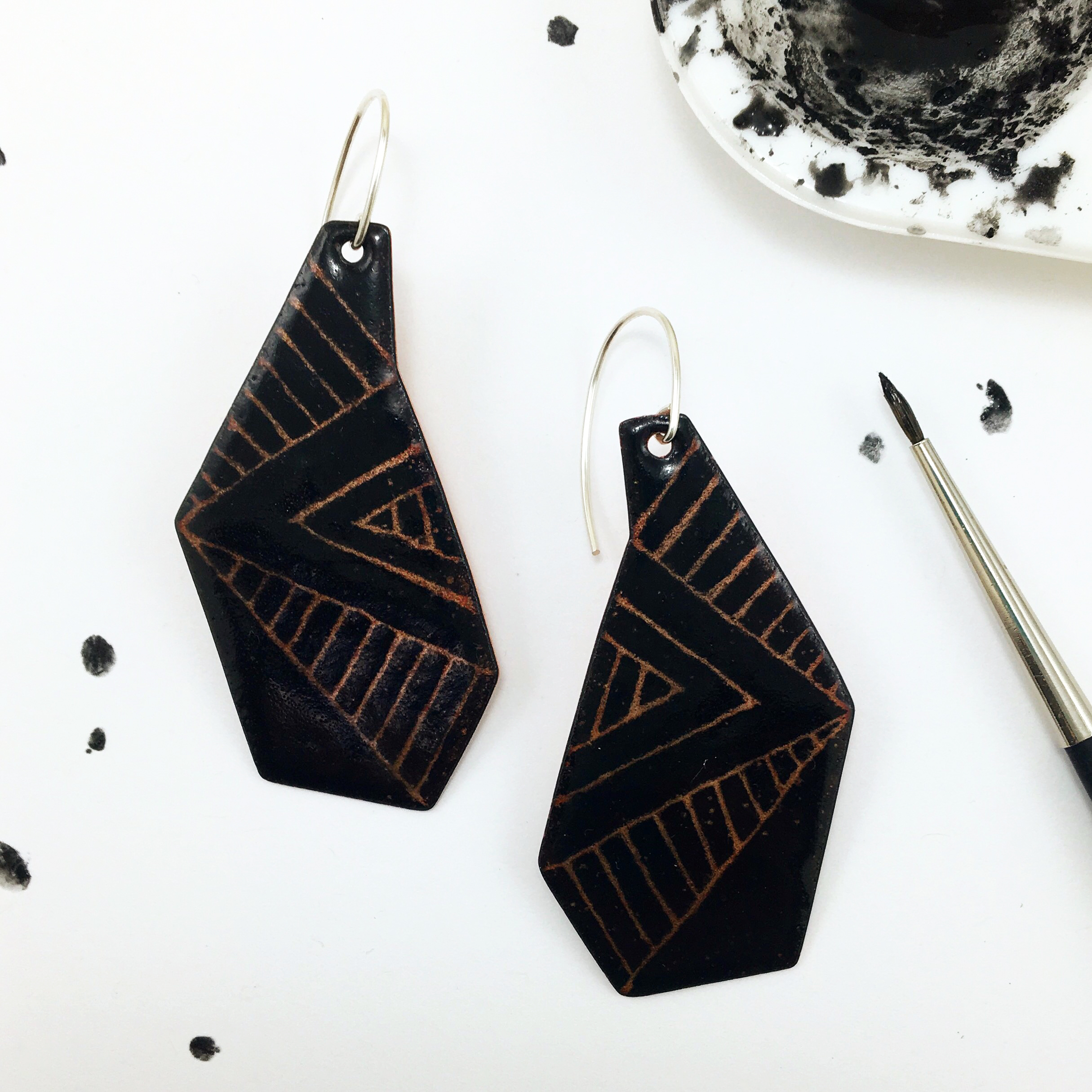 Today's creative experiment: Geometric enamel earrings with sgraffito in overglaze black over clear enamel that lets the copper beneath it shine through.